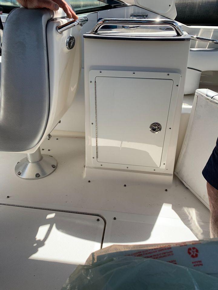 Interior of a 2006 Sea Ray 250 SLX boat, featuring seating and storage compartment.
