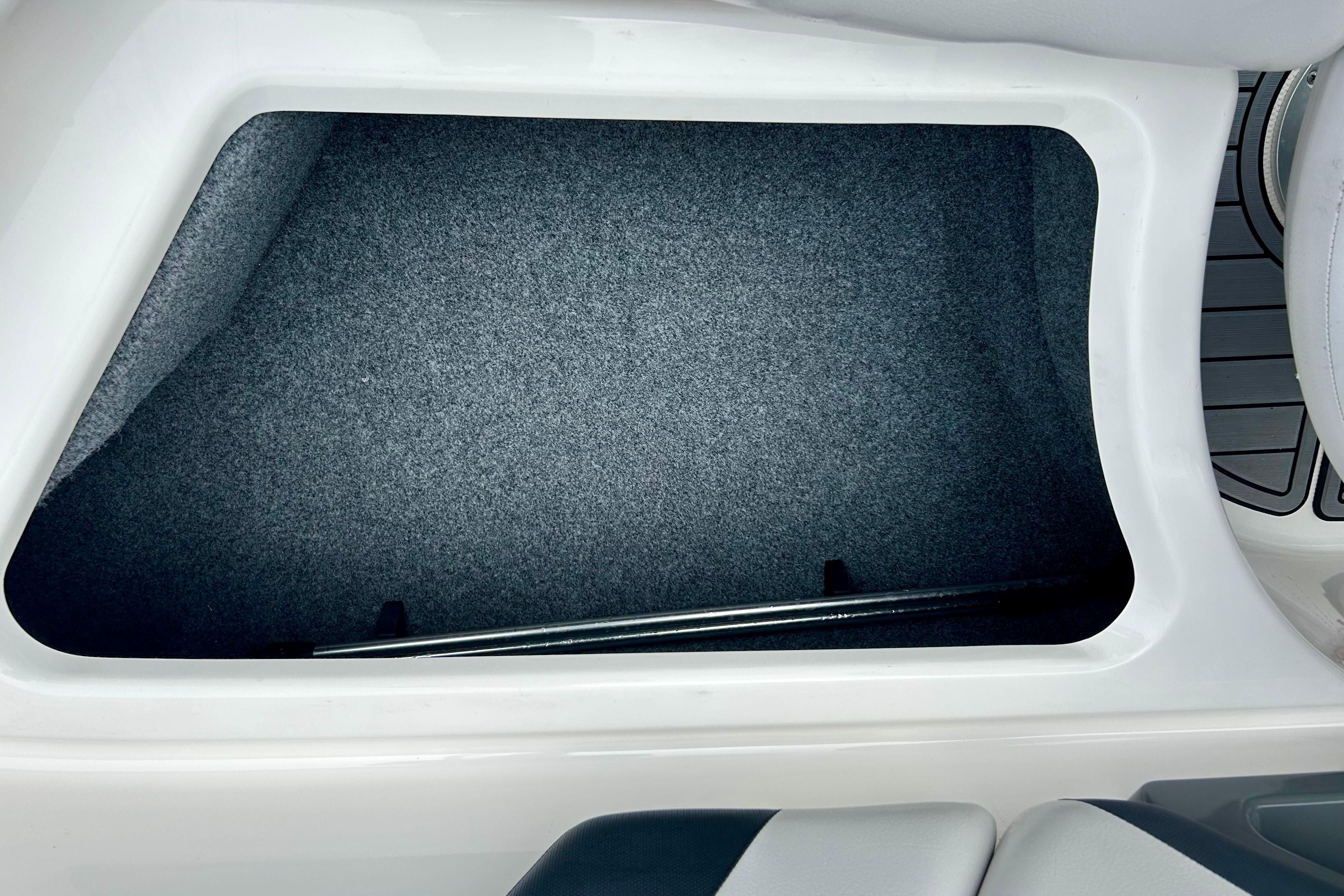 Storage compartment in 2015 Yamaha AR210 boat, featuring a spacious, carpeted interior.
