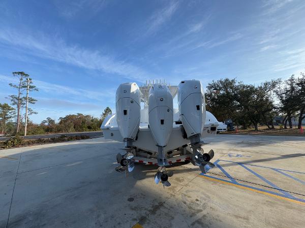 2025 Yellowfin 39 Offshore boat with four powerful outboard engines, parked outdoors.