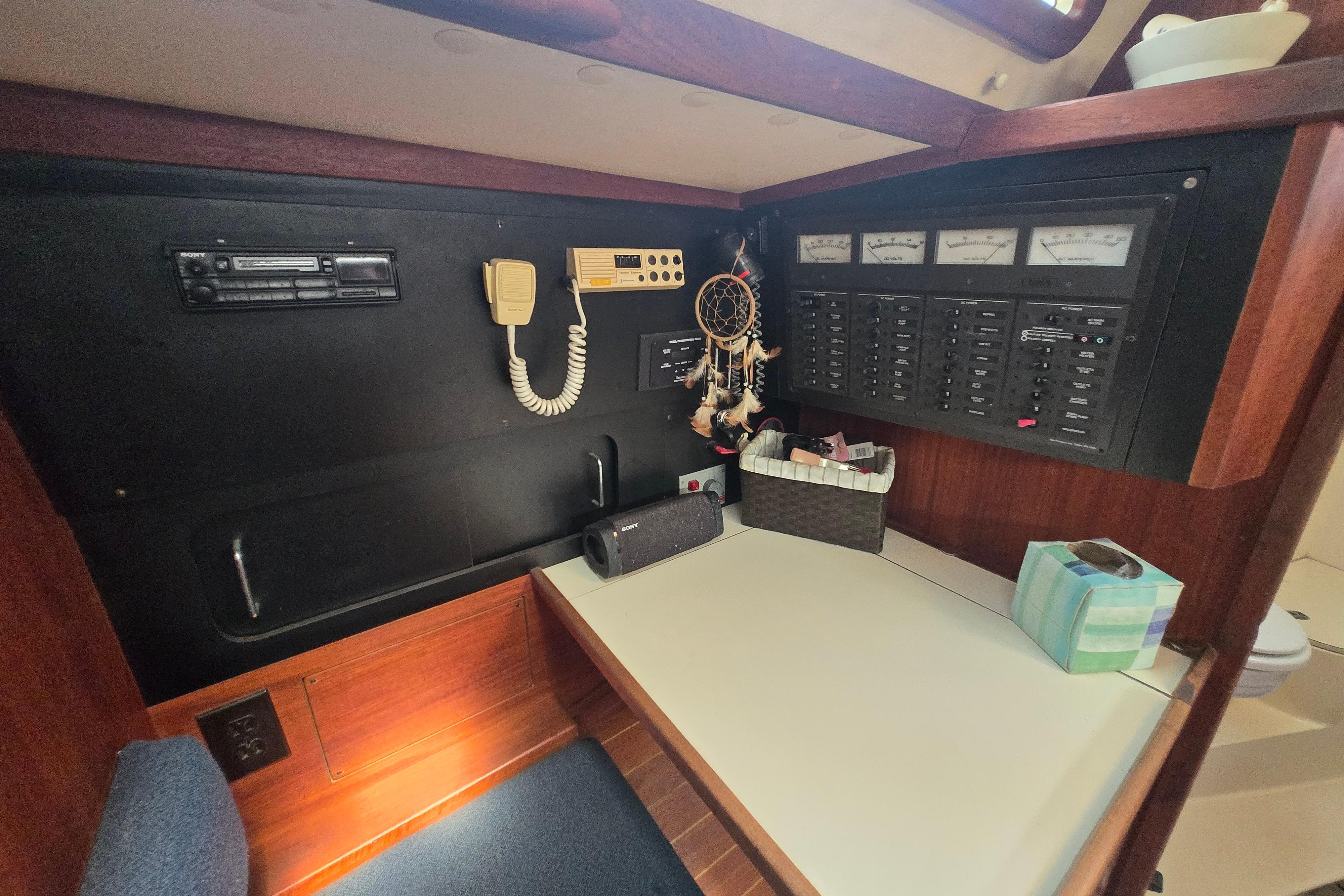 Navigation station of a 1988 Sabre 38 sailboat with communication equipment and control panel.