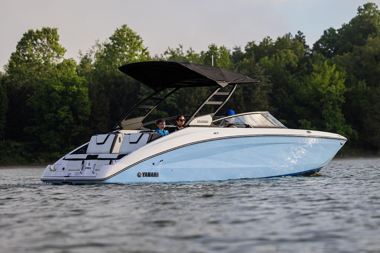 Manufacturer Provided Image: 2026 Yamaha Boats 252SE cruising on a serene lake with lush green trees in the background.