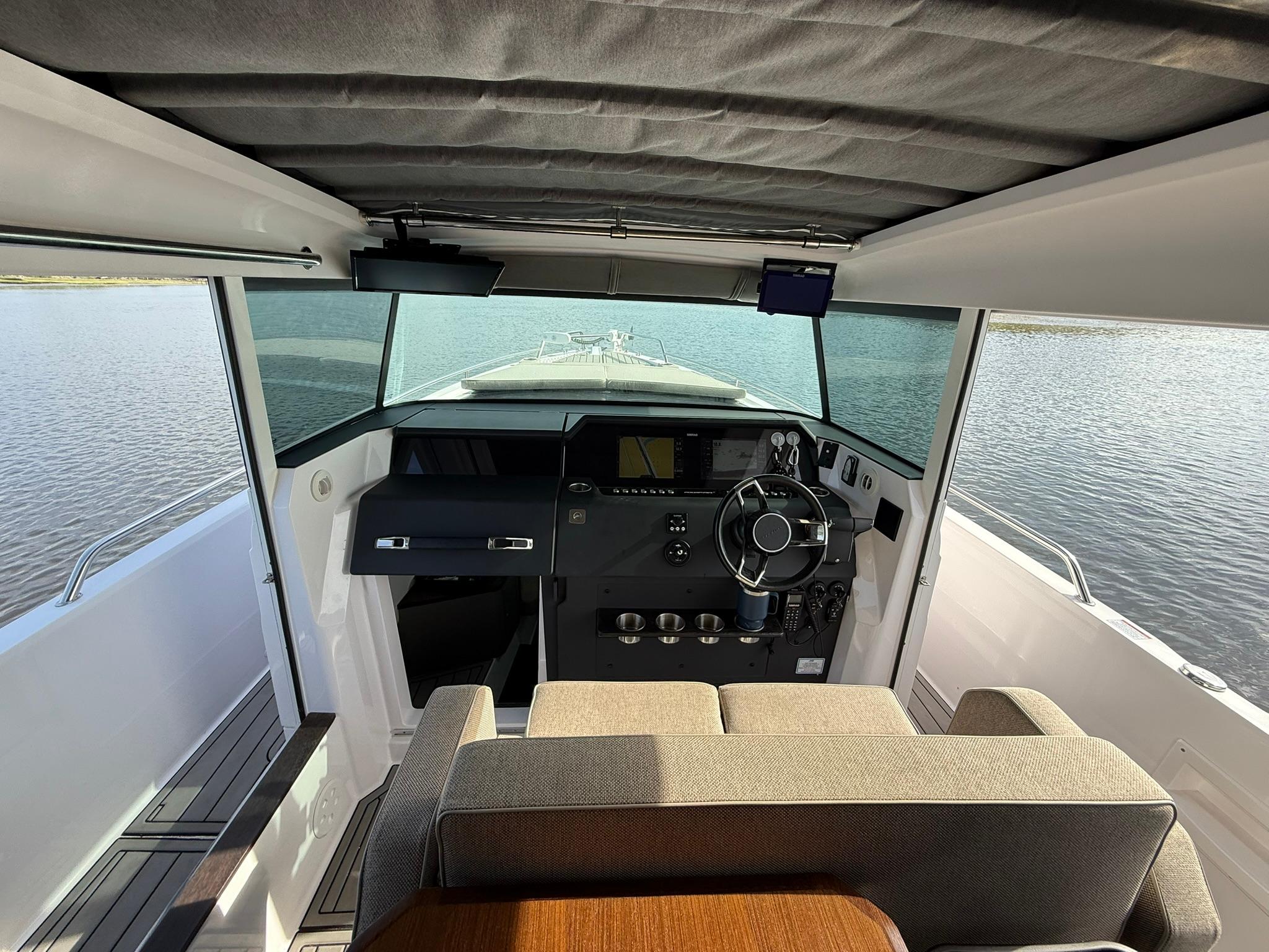 2023 Axopar 37 Cross Cabin interior with modern helm and panoramic water view.