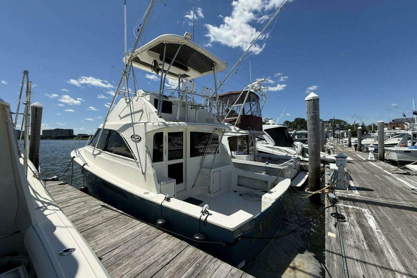 1988 Ocean Yachts 35 Super Sport docked at marina under clear blue sky.