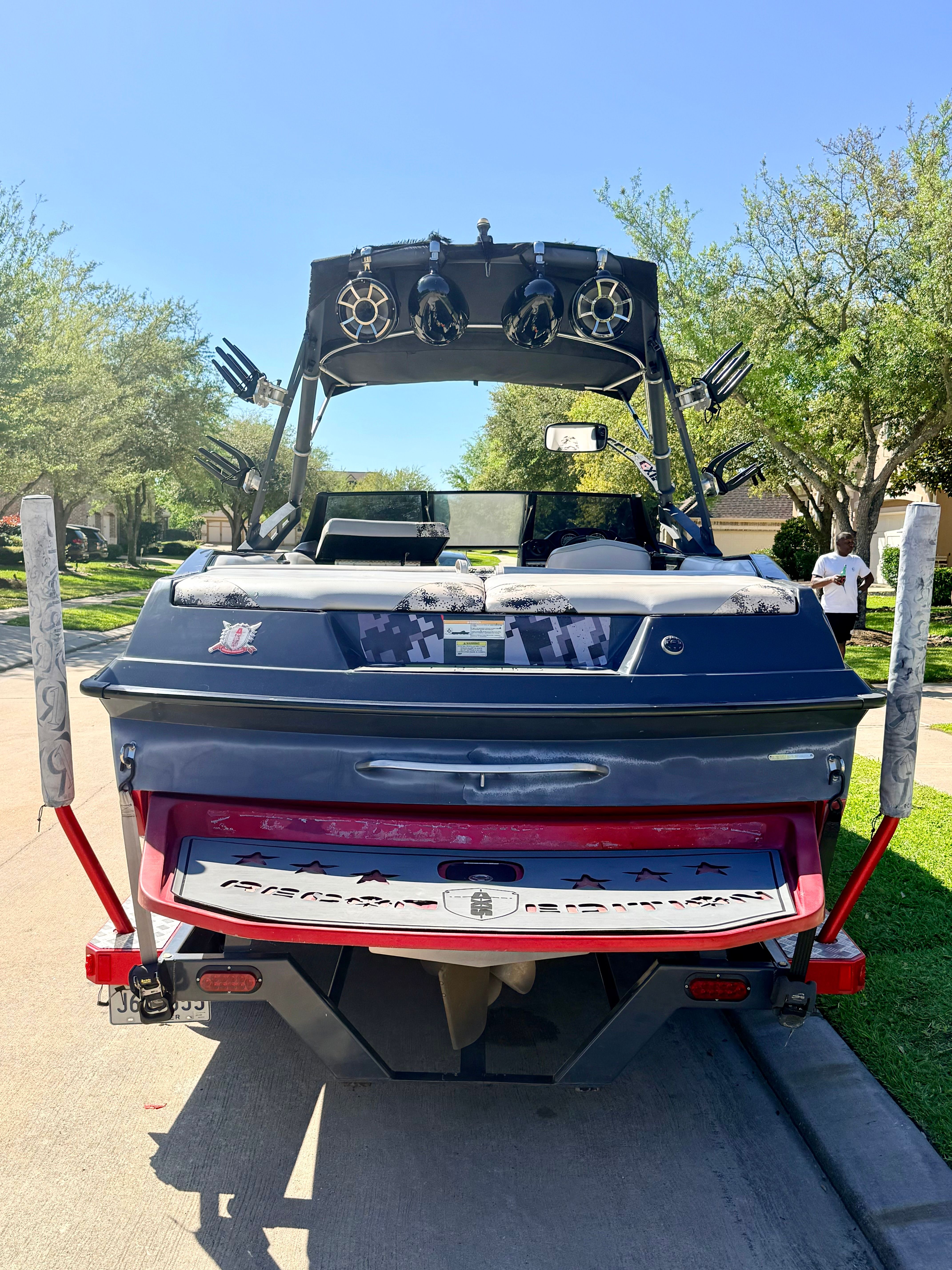 Rear view of a 2013 Axis A22 boat on a street.