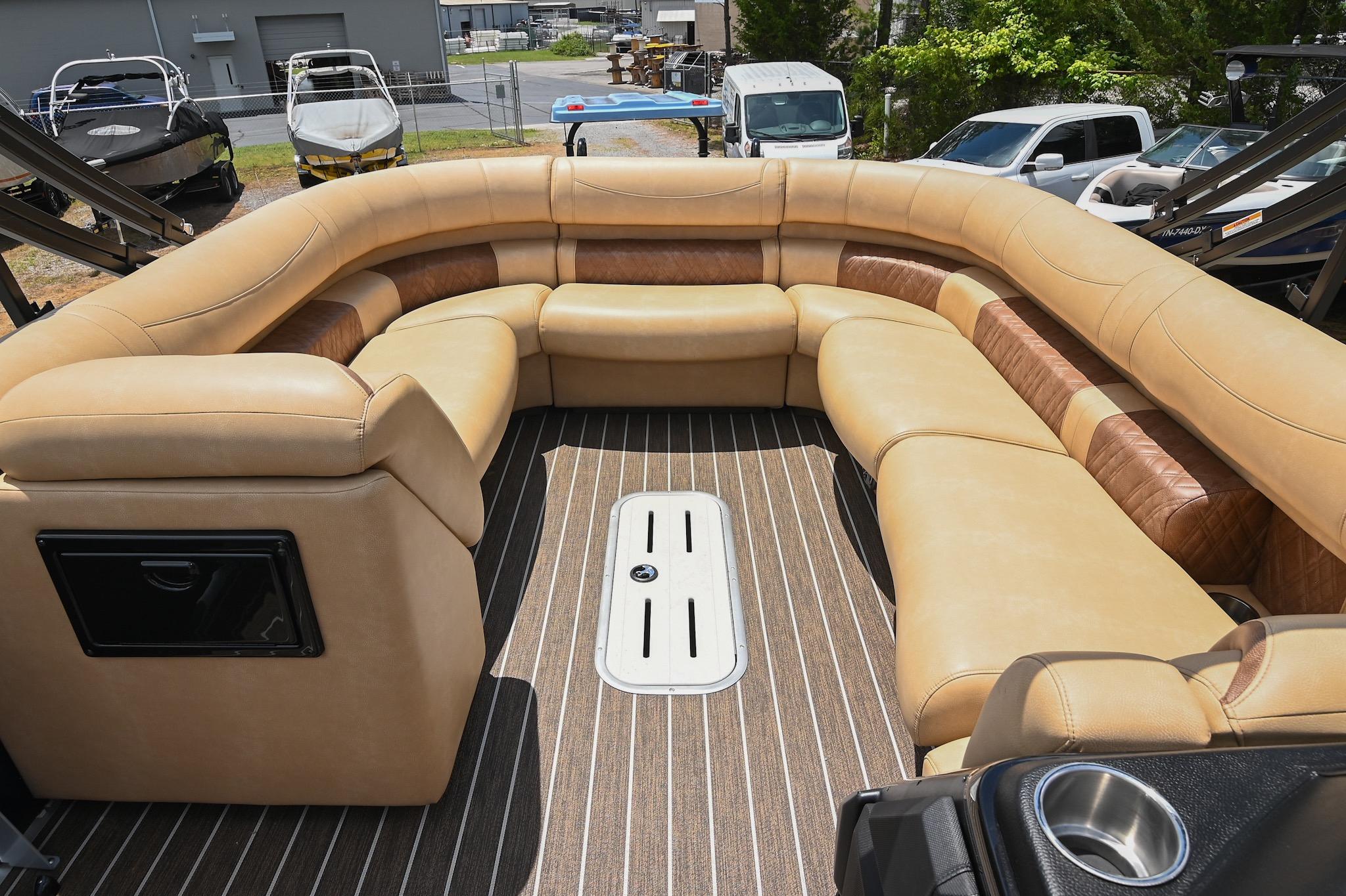 Luxurious seating on 2023 Premier 270 Intrigue RF boat, featuring tan upholstery and striped flooring.