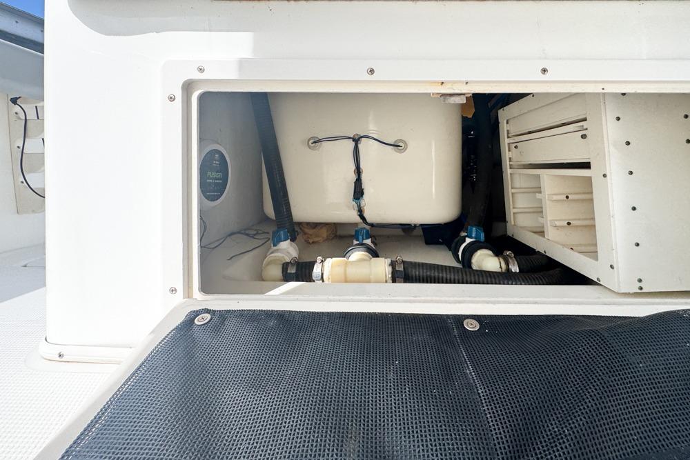 2018 Mako 284 Center Console boat storage compartment with visible plumbing and wiring.