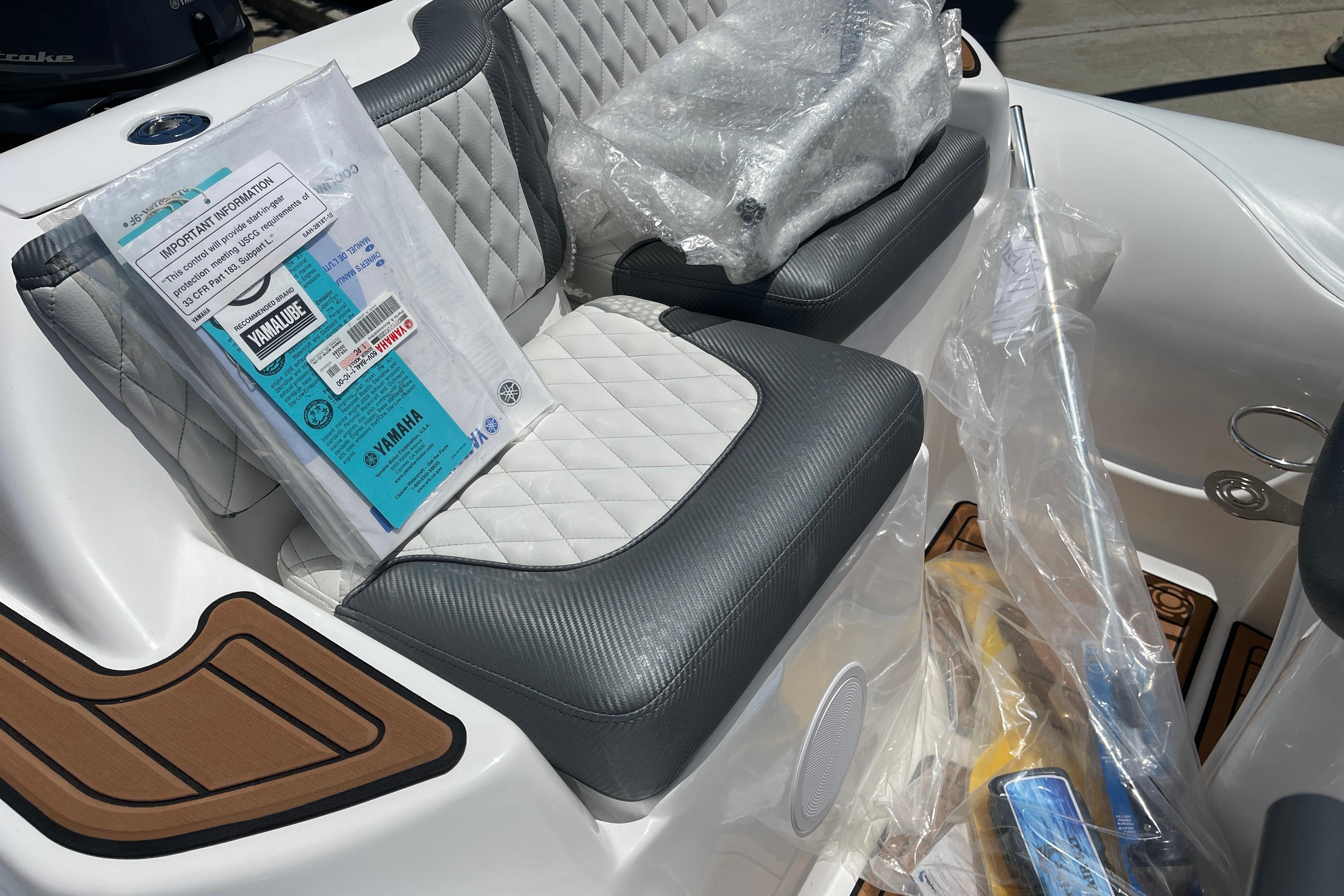 2025 Caribe DL11 boat interior with quilted seats and Yamaha manual on seat.