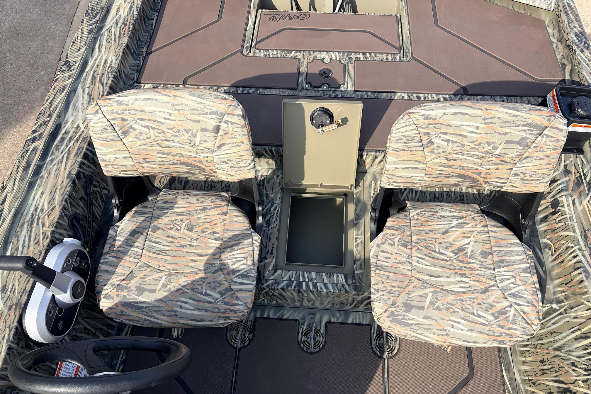 2026 Tracker Grizzly 1754 SC boat interior with camo seats and steering console.