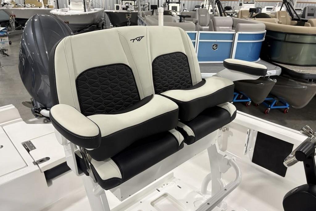 2026 Tidewater 2210 Carolina Bay boat seats, featuring black and white cushioned design in a showroom.