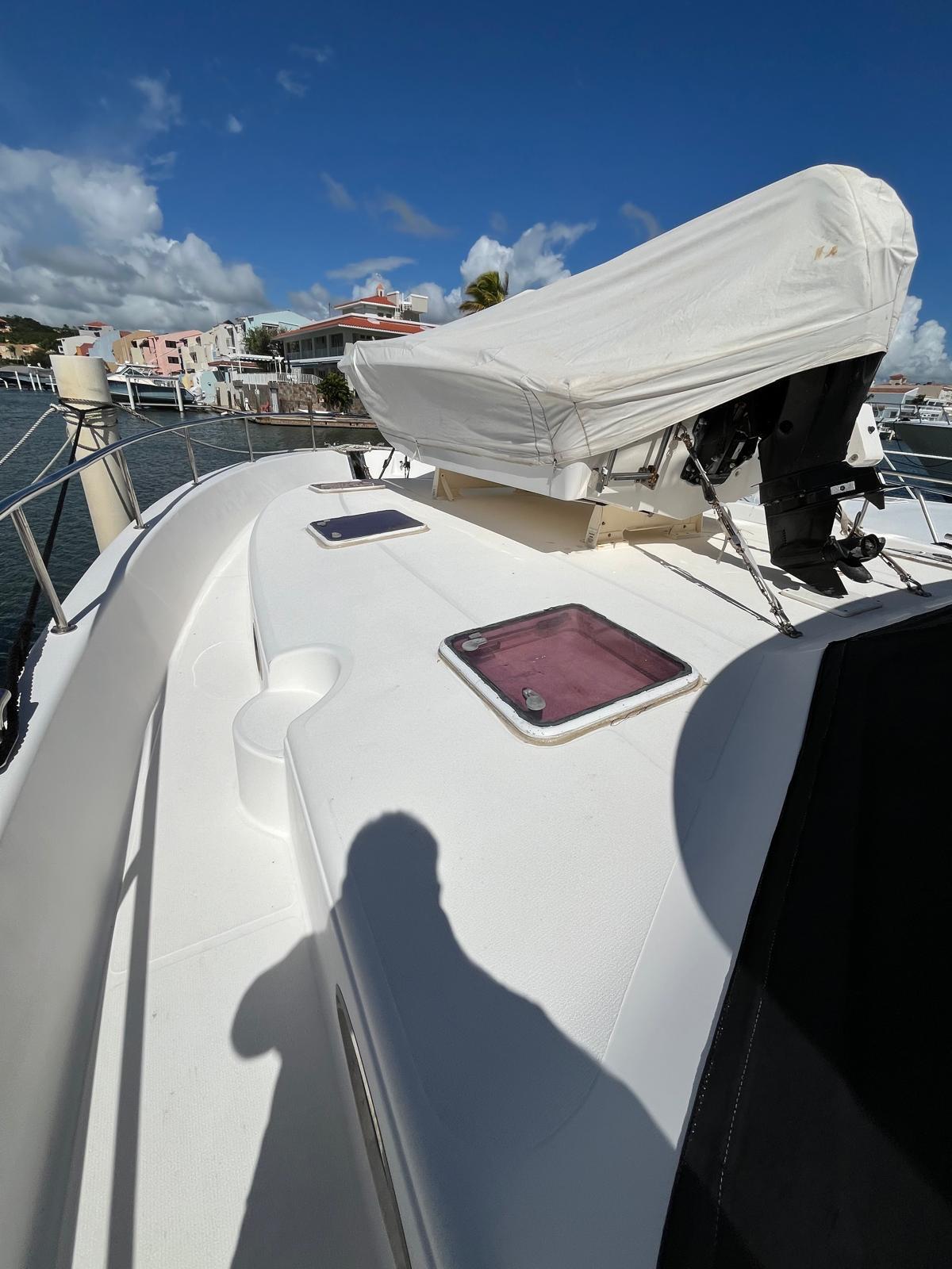 2007 Maritimo M60 yacht deck with covered equipment, docked in a marina under blue skies.