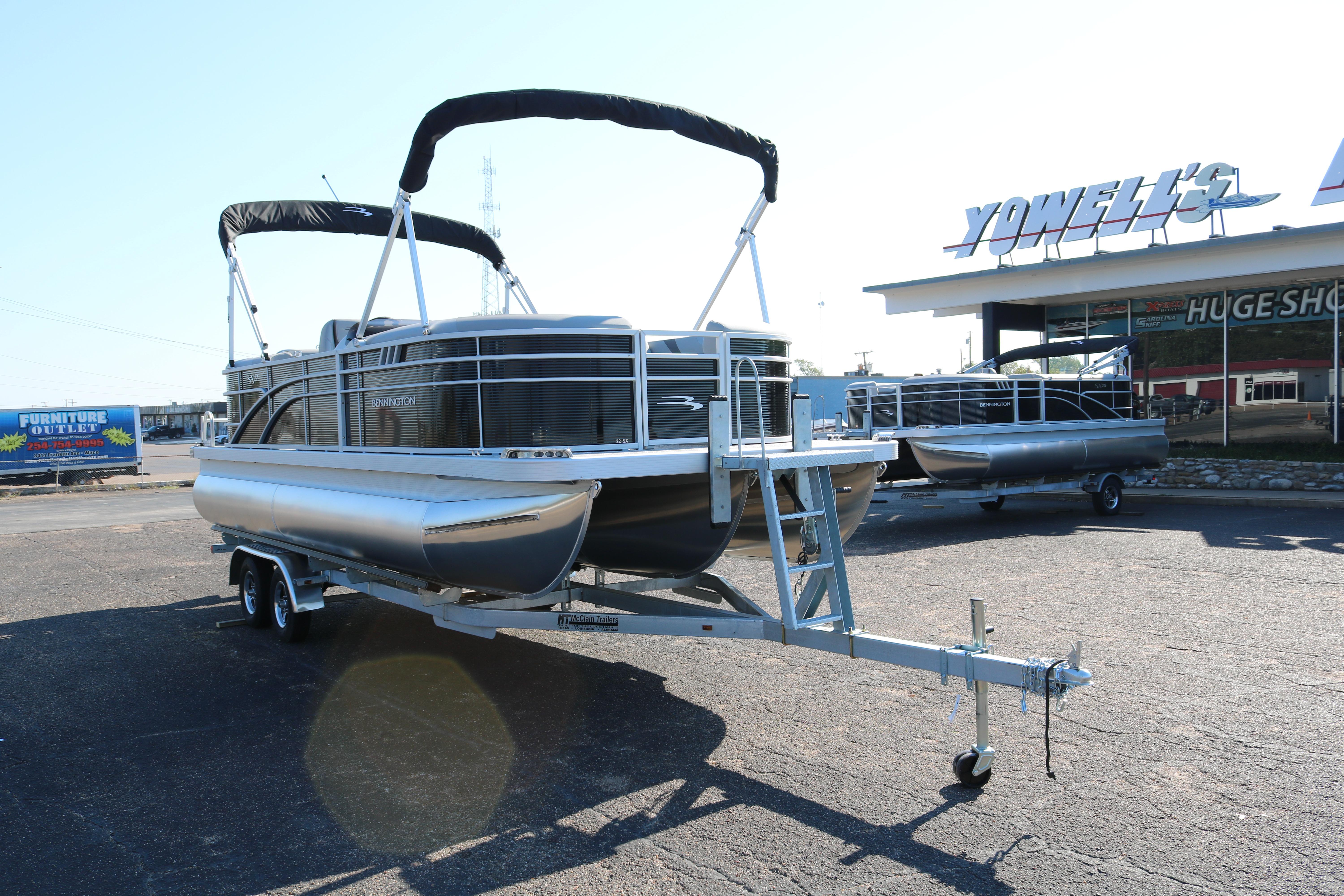 2026 Bennington 22SX Stern Radius pontoon boat on trailer in dealership lot.