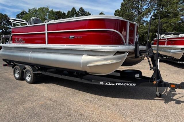 2026 Sun Tracker Party Barge 20 DLX pontoon boat on trailer, parked outdoors.