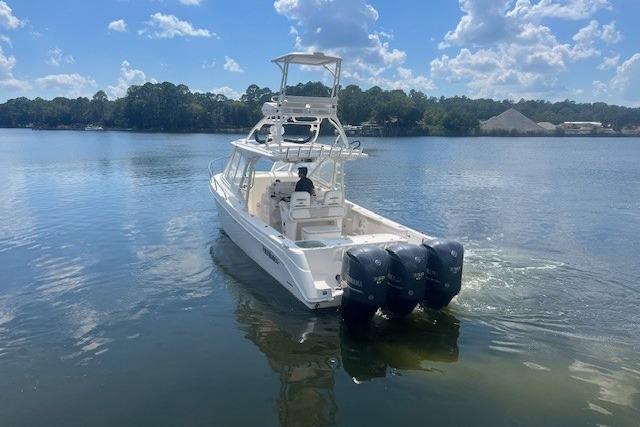 2011 Everglades 350LX boat with triple outboard engines on a calm lake.