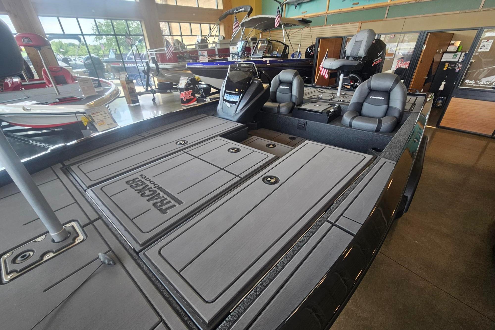 2026 Tracker Savage 215 boat interior with sleek seating and storage compartments in showroom.