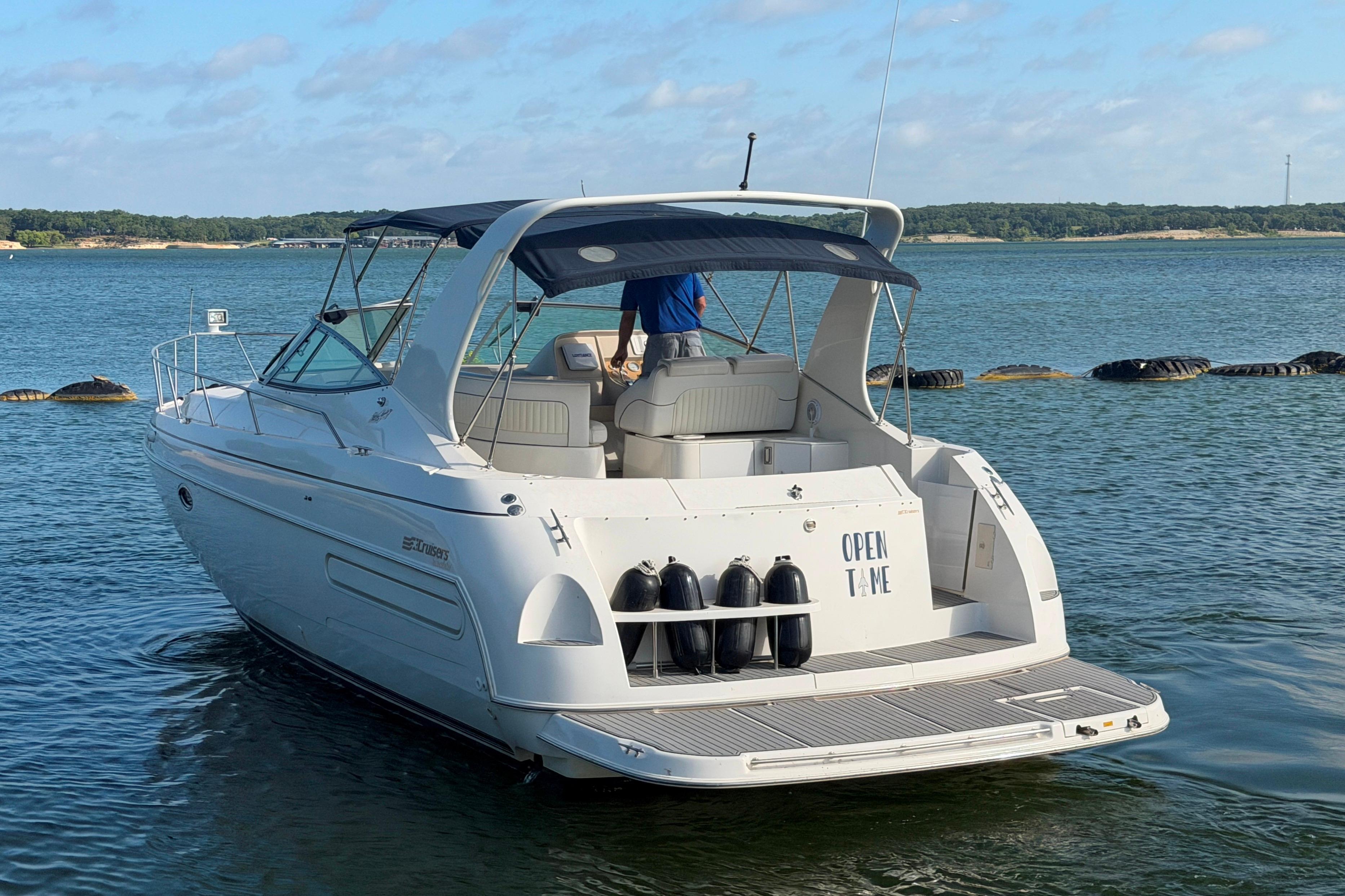 1997 Cruisers 3575 yacht on calm water, featuring a spacious deck and canopy.