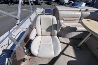 2012 Avalon Tahoe boat interior with beige seating and table.