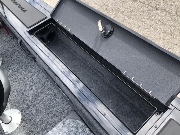 2025 Tracker Targa V18 Combo boat storage compartment, open and empty, with carpeted interior.