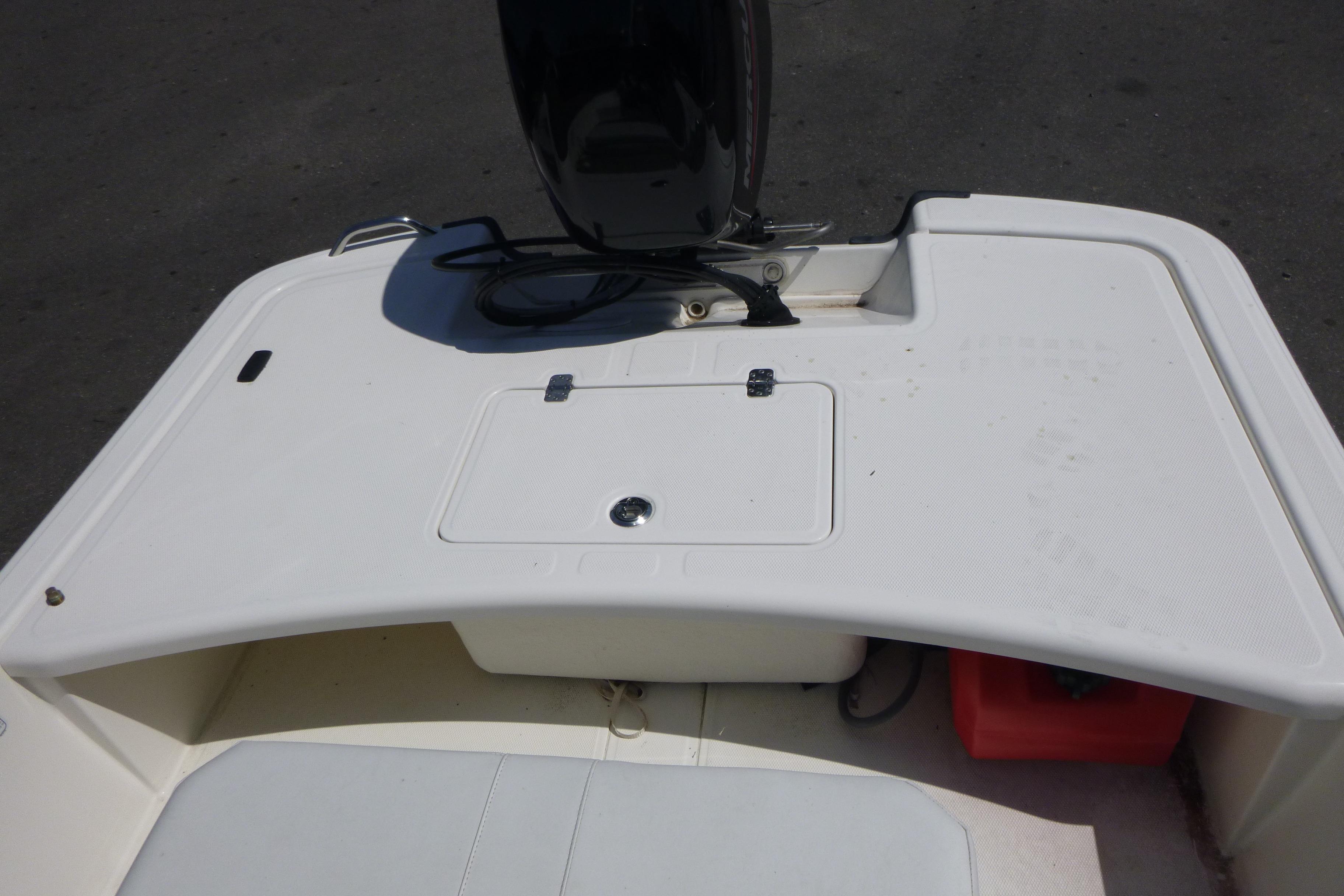 2024 Mako Pro Skiff 17 CC boat deck with storage compartment and motor.