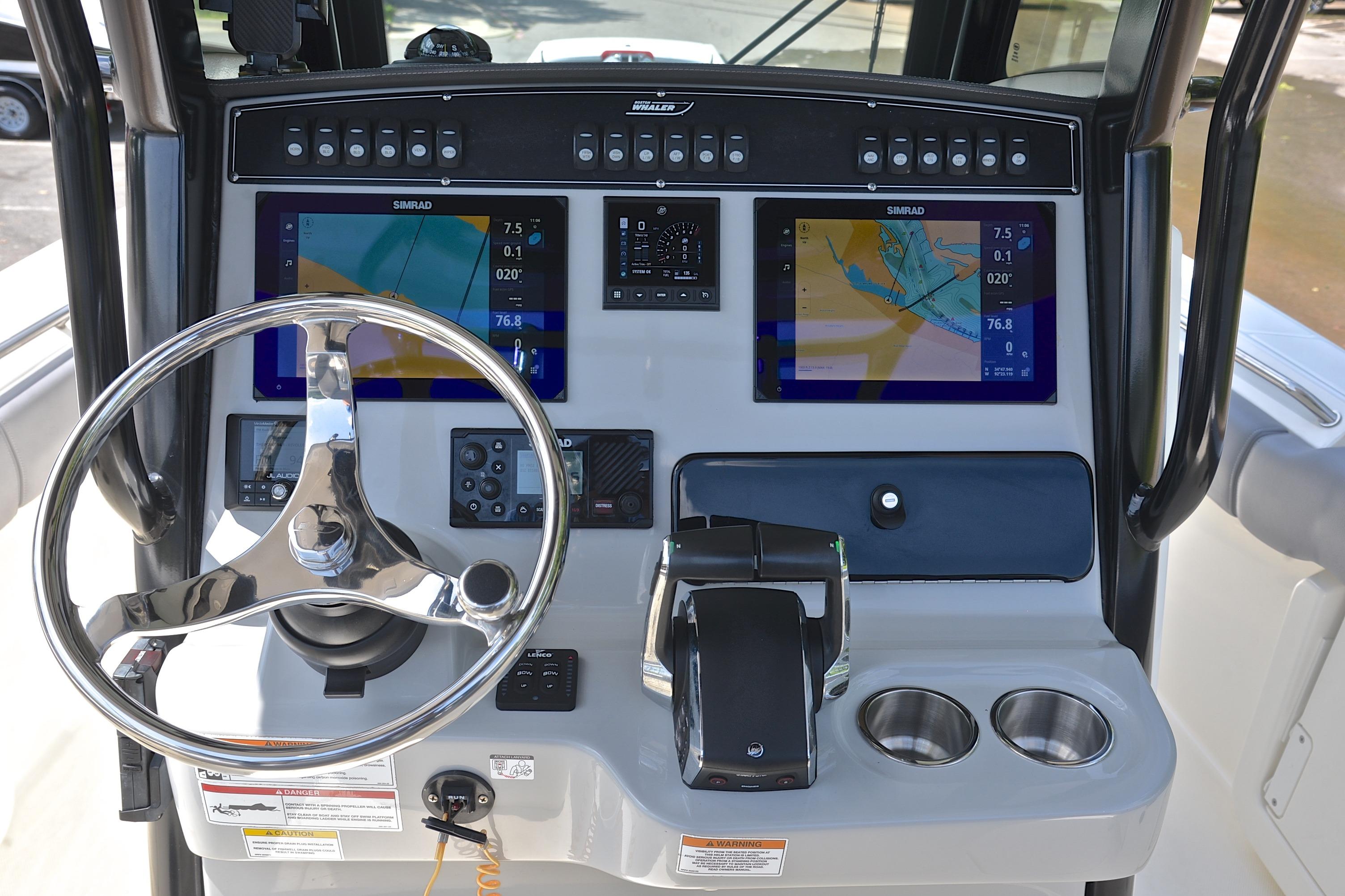 2024 Boston Whaler 250 Outrage helm with dual Simrad displays and stainless steel steering wheel.