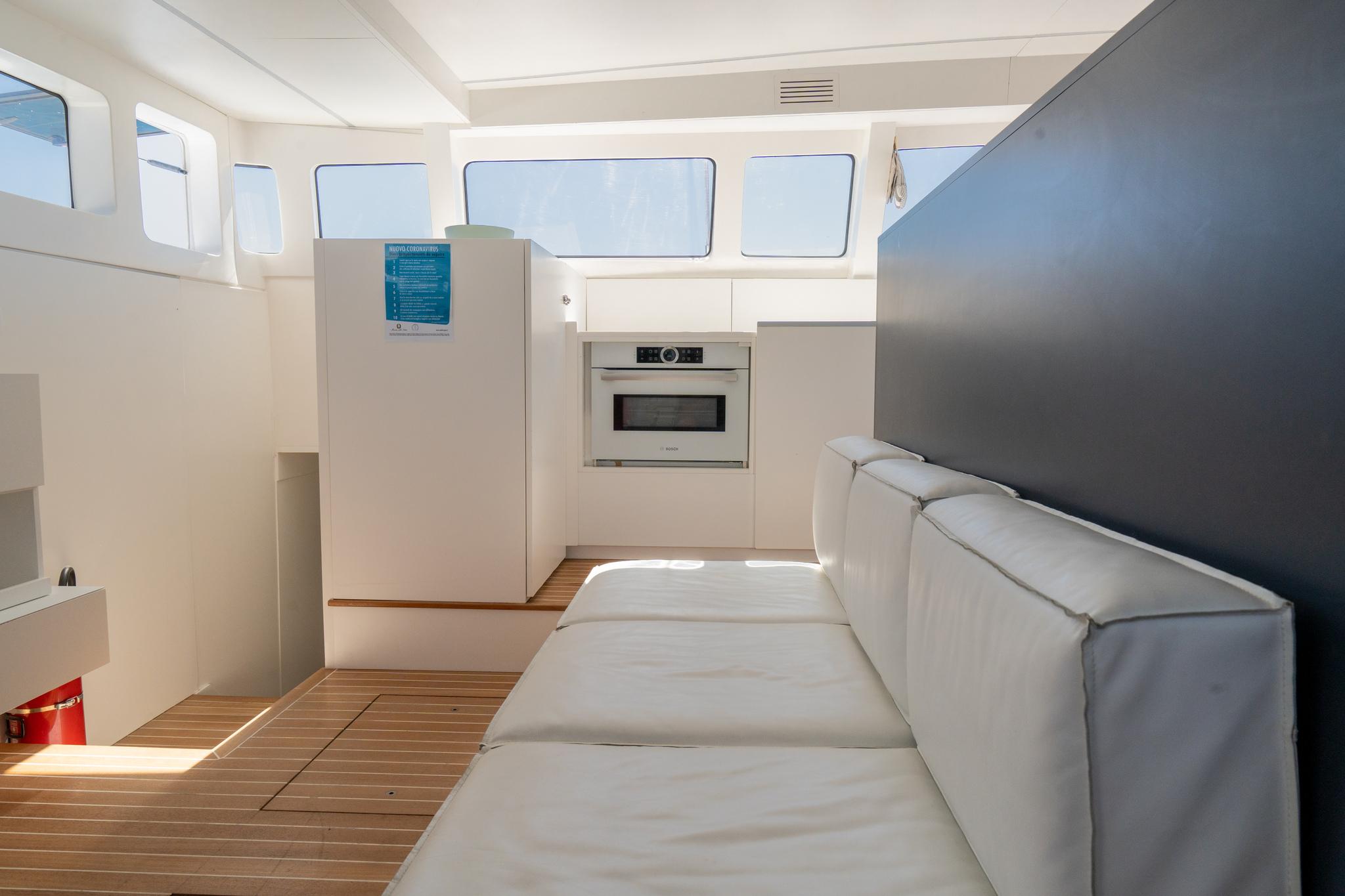 Interior of 2016 Custom Set Marine 625 yacht with modern seating and kitchen area.