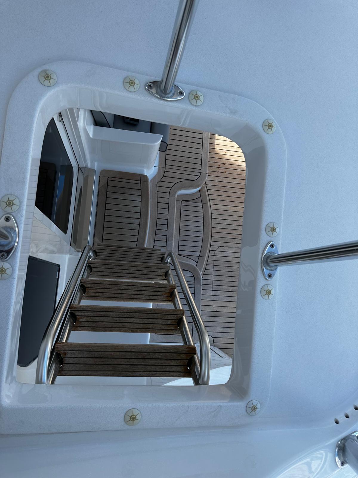Stairway on 2011 Hatteras GT60 yacht with wooden deck and metal railings.