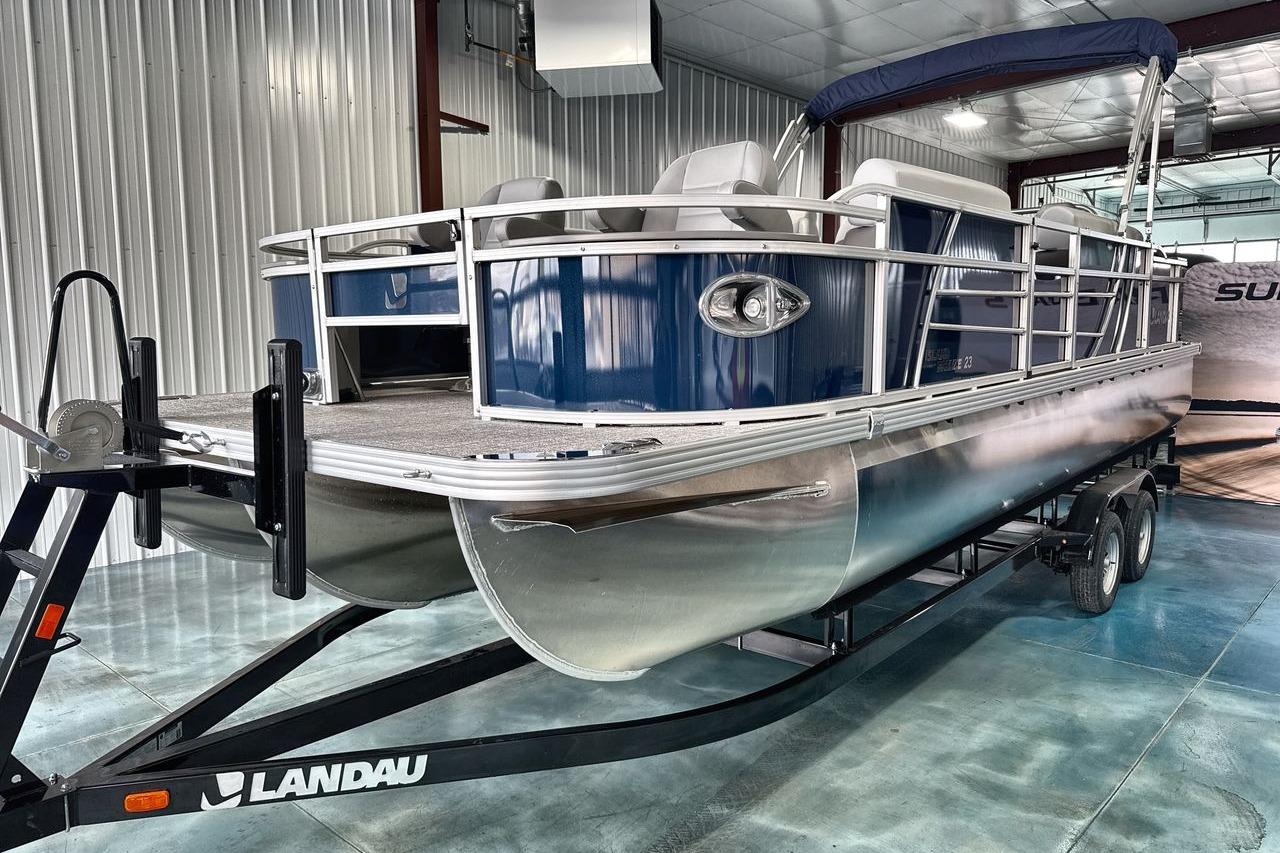 2026 Landau Island Breeze 23F pontoon boat on trailer in a metal garage.