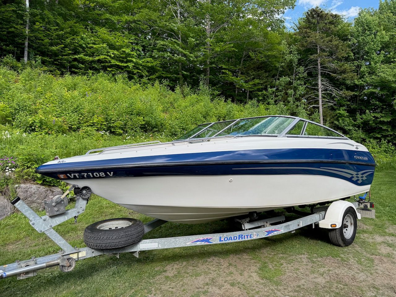 2000 Crownline 192 BR boat on trailer in lush greenery.