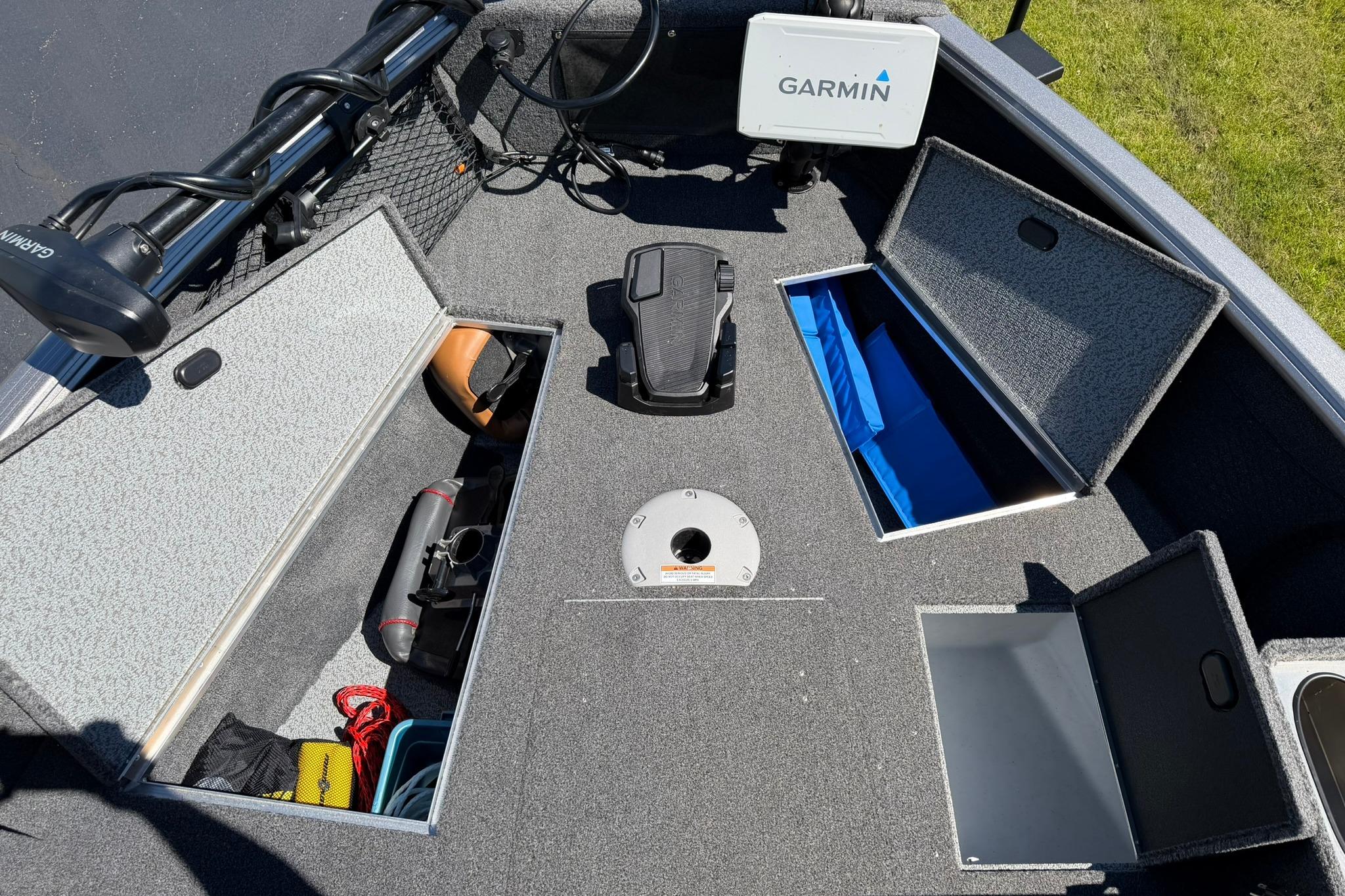 2024 Lund 1875 Impact XS Sport boat interior with storage compartments and Garmin equipment.