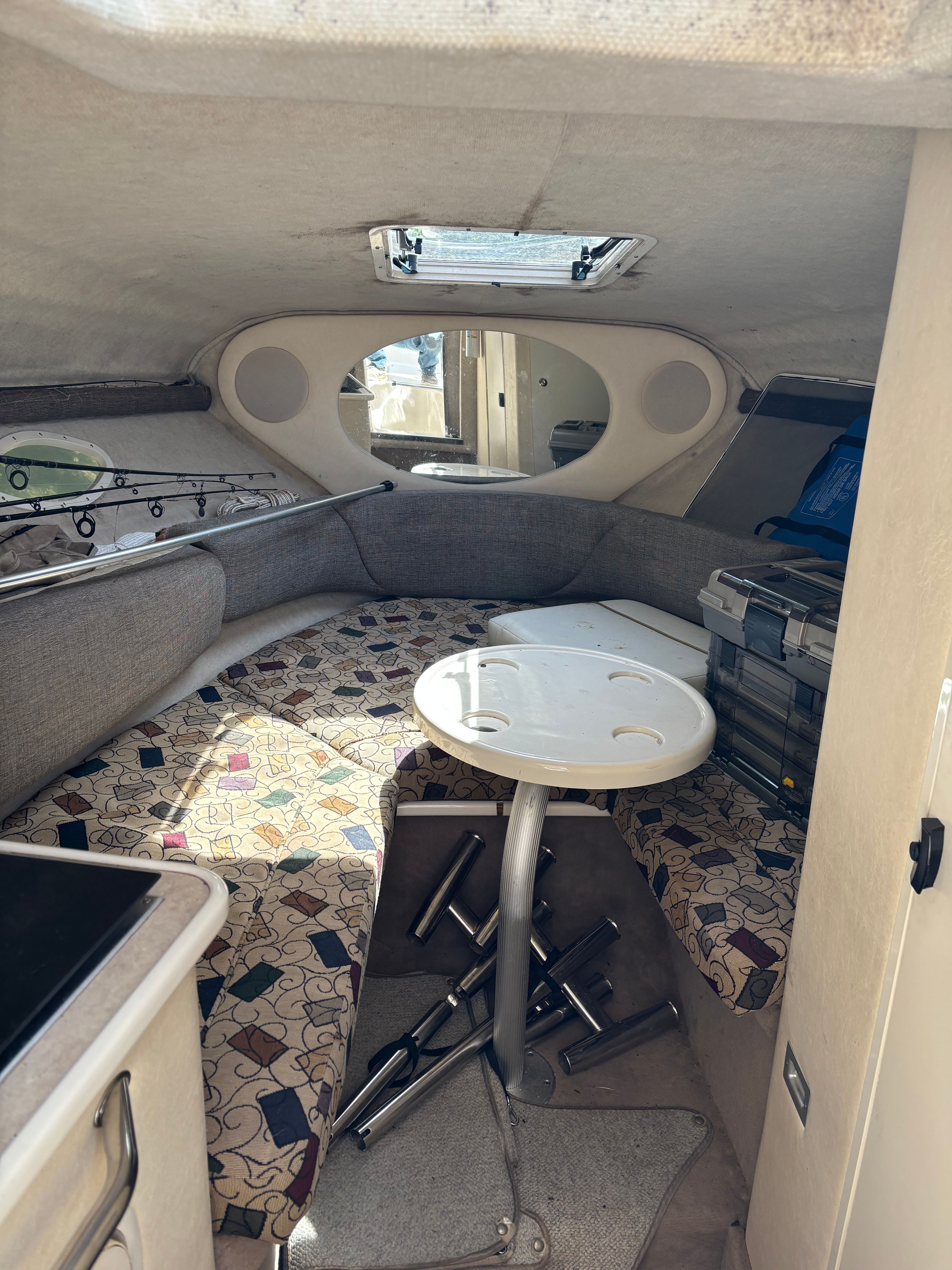 Interior of a 2001 Sea Ray 245 Weekender with table and seating area.