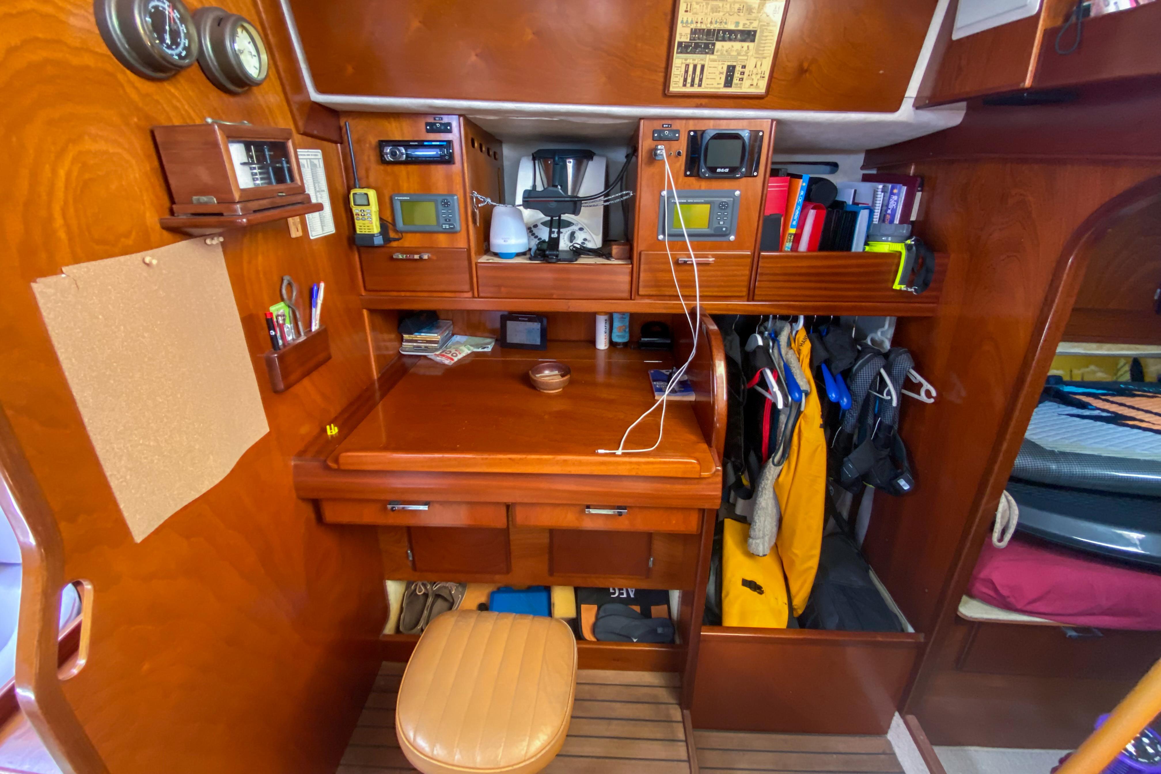 Navigation station inside a 1991 Amel Super Maramu yacht, featuring wooden cabinetry and nautical instruments.