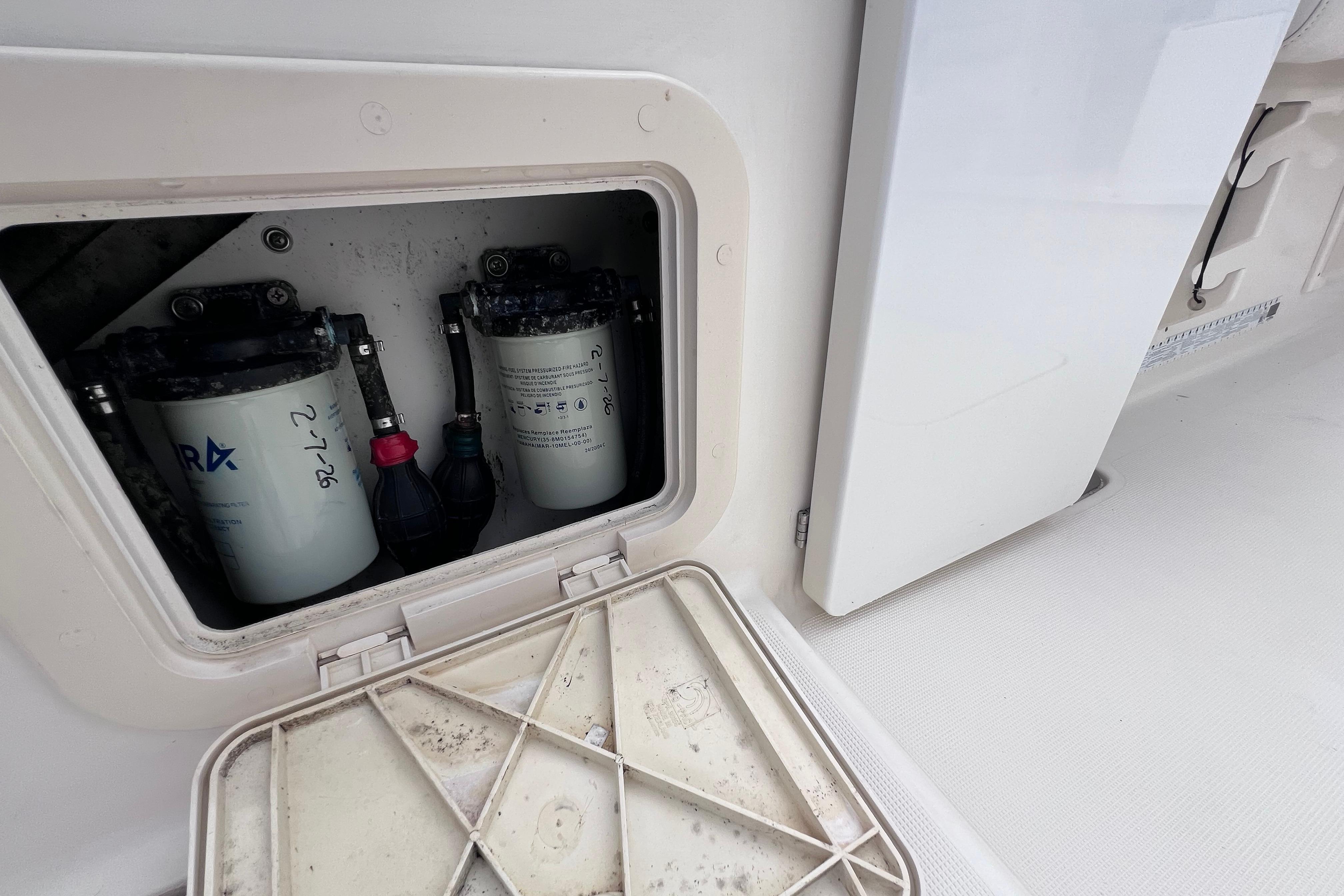 Fuel filter compartment of a 2005 Pursuit 3070 Offshore boat, showing maintenance details.