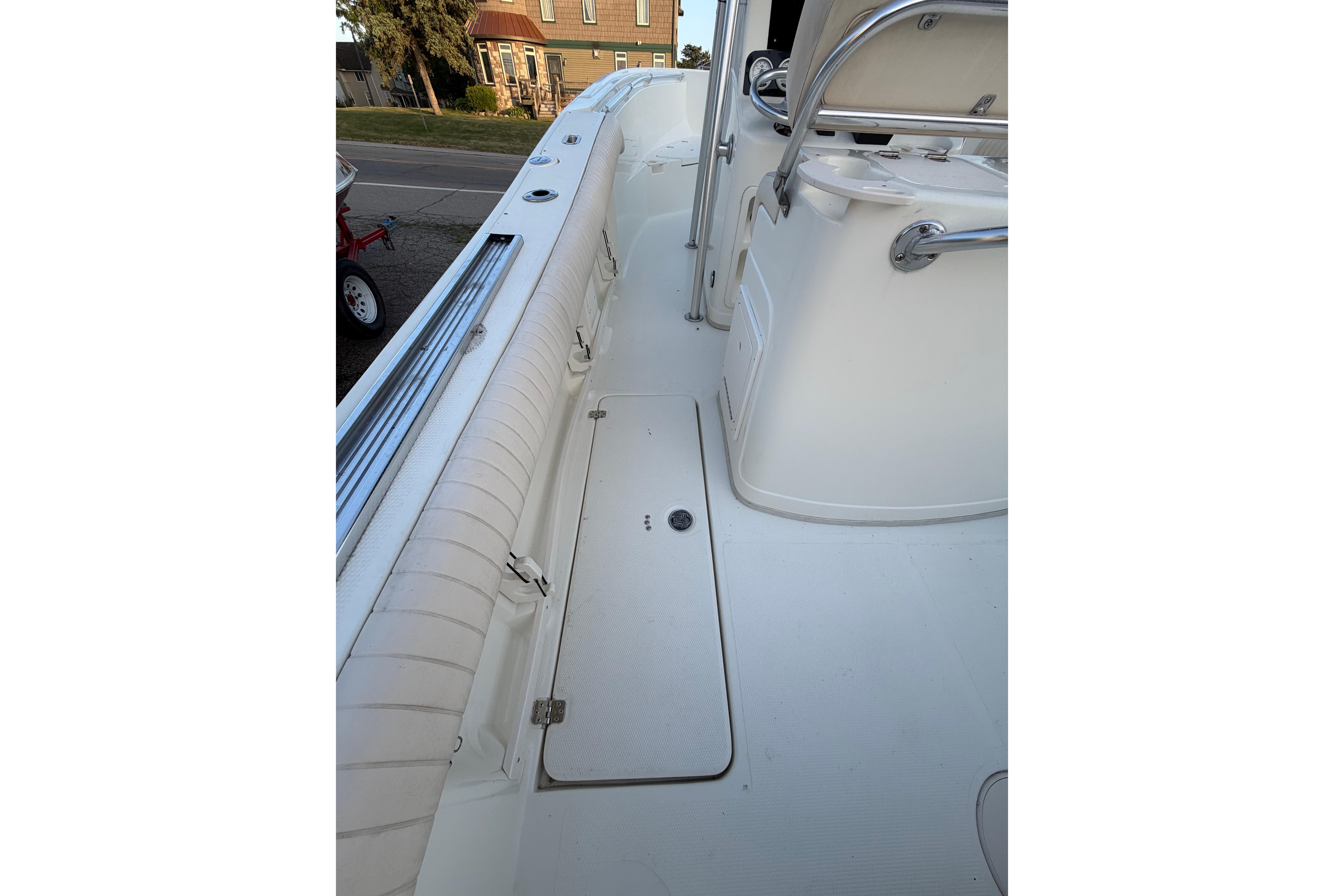 2007 Mako 234 Center Console boat interior with white seating and storage compartment.