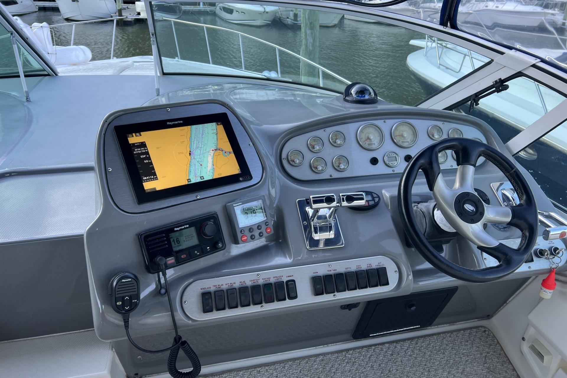 Helm of 2005 Cruisers Yachts 370 Express with navigation equipment and steering wheel.