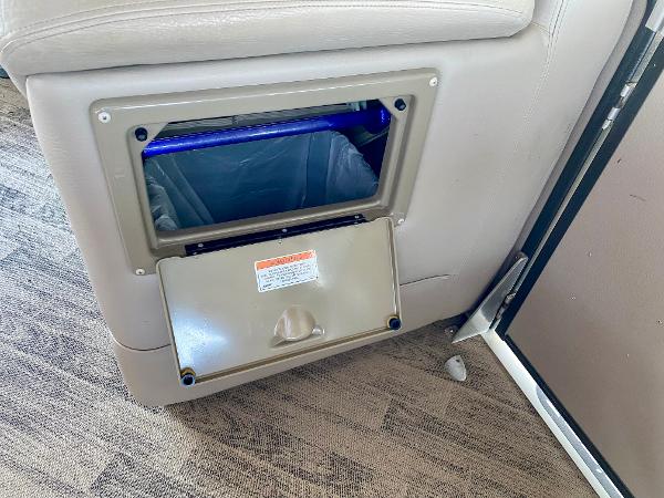 A seating area with a built-in trash bin on a boat.