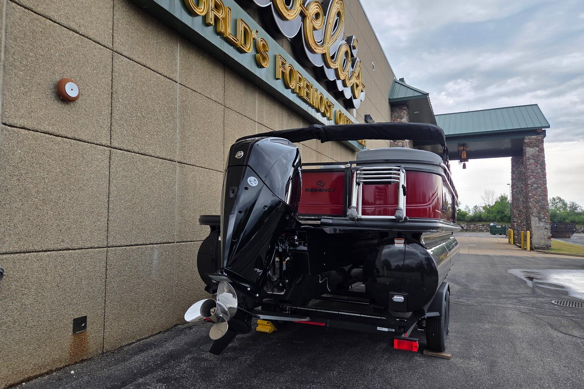 2026 Regency 230 DL boat parked outside a large retail store.