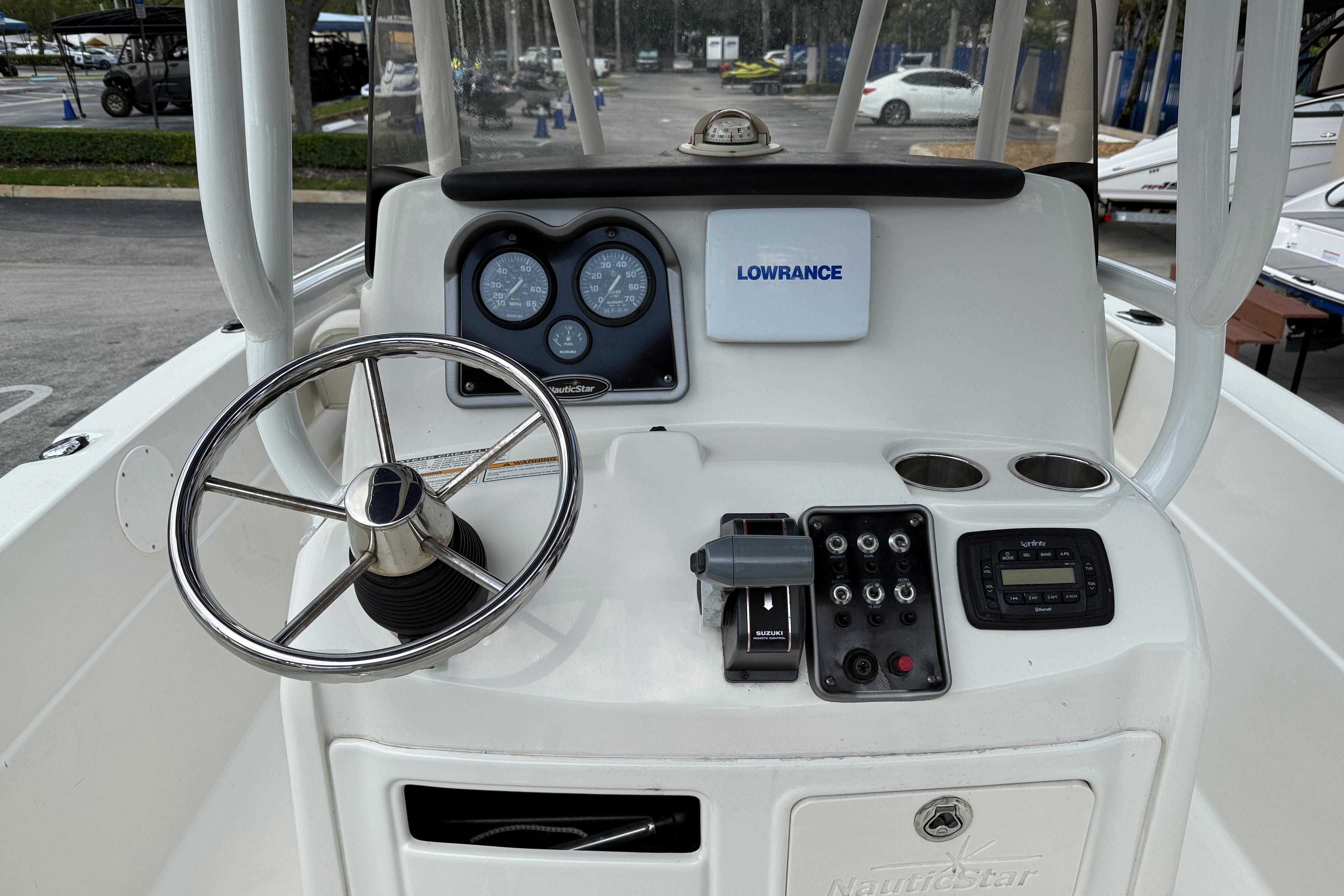 2015 NauticStar 231 Coastal boat dashboard with steering wheel and navigation instruments.