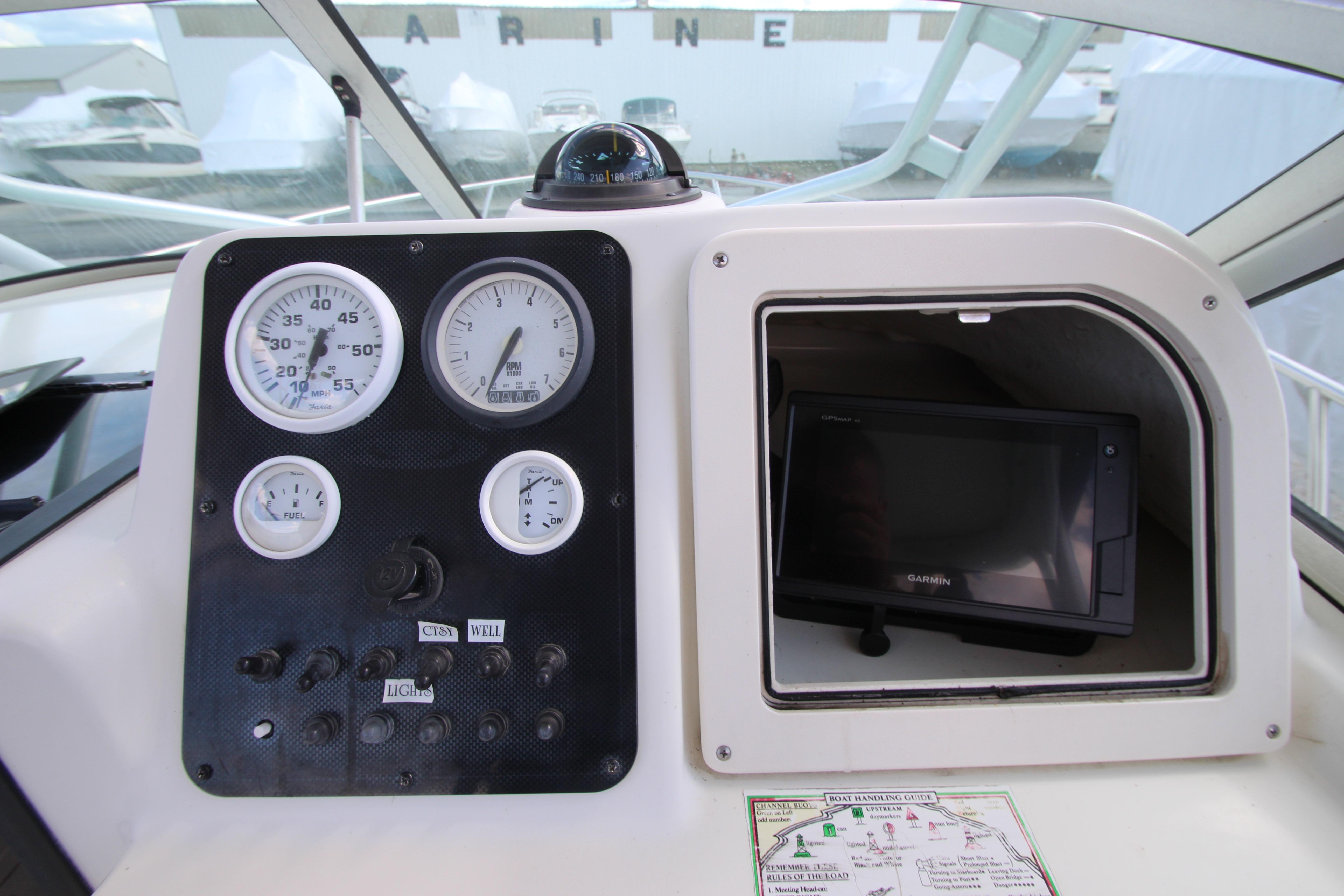 Dashboard of a 2002 Hydra-Sports 230 WA boat with gauges and Garmin GPS.
