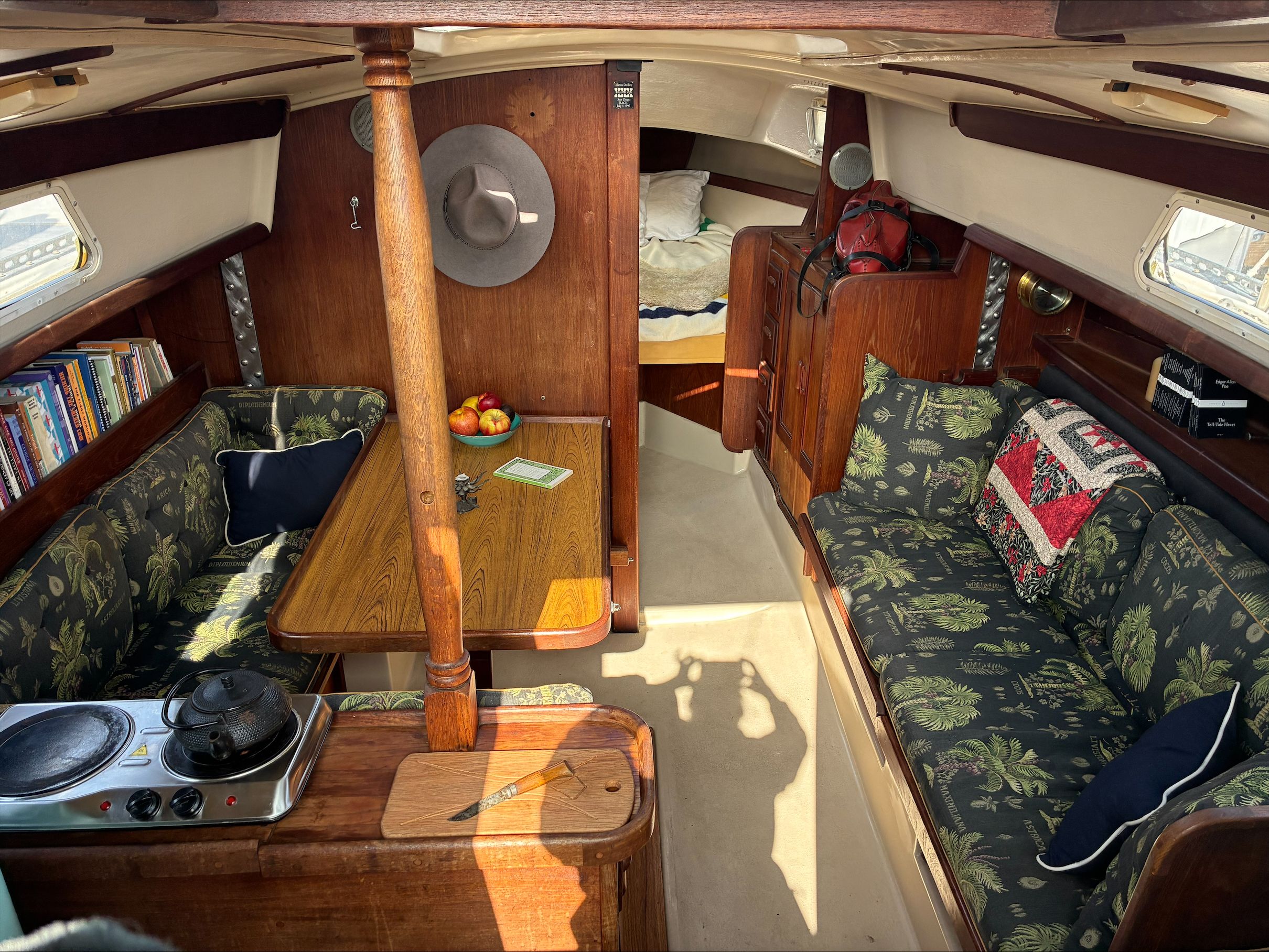 Interior of a 1980 Newport 30 sailboat with cozy seating area and kitchenette.