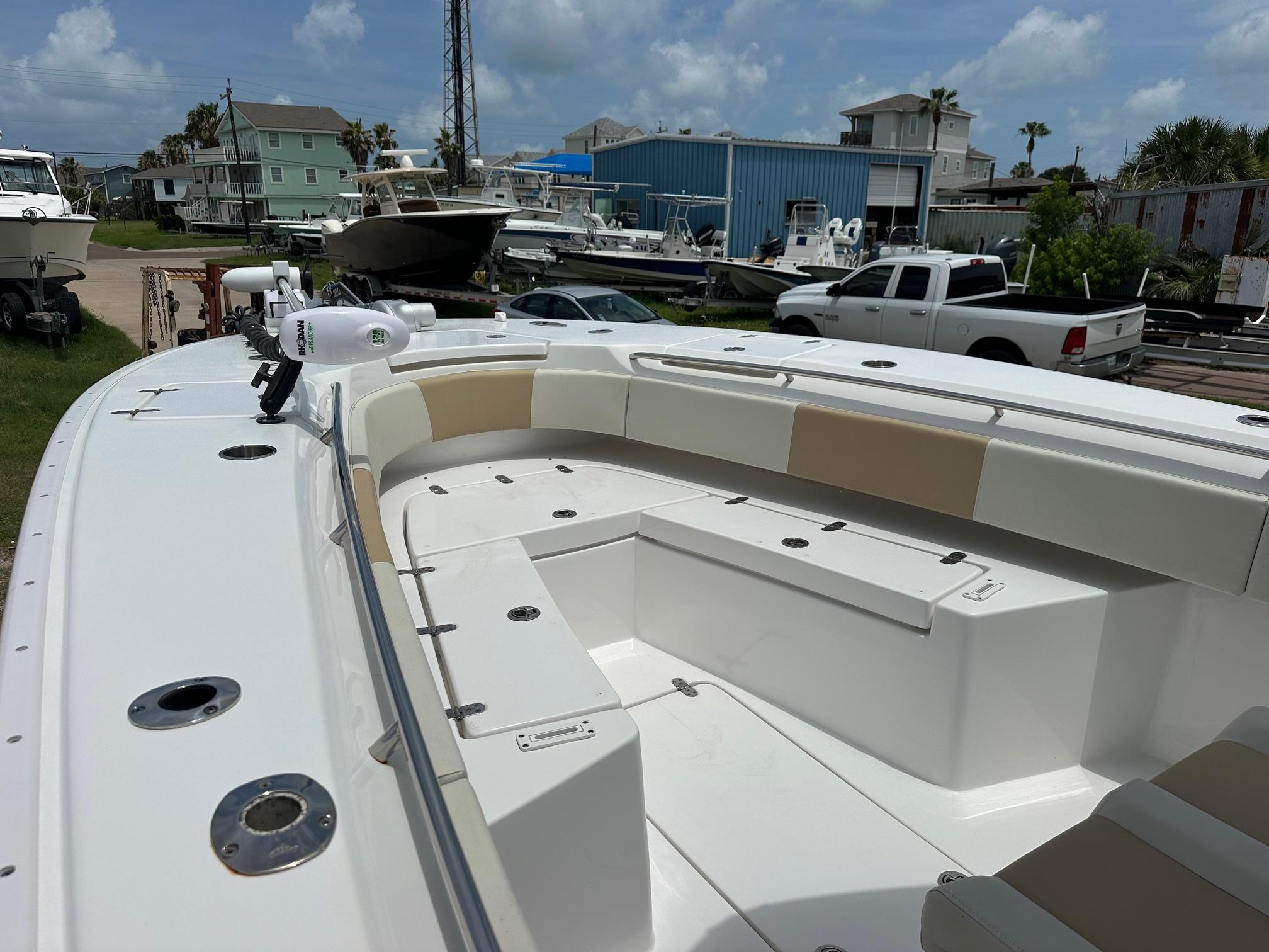 2023 Cape Horn 32xs boat with spacious seating, docked in a marina under a cloudy sky.
