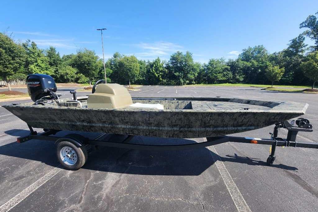 2026 Tracker Grizzly 1648 SC boat on trailer in parking lot, sunny day.