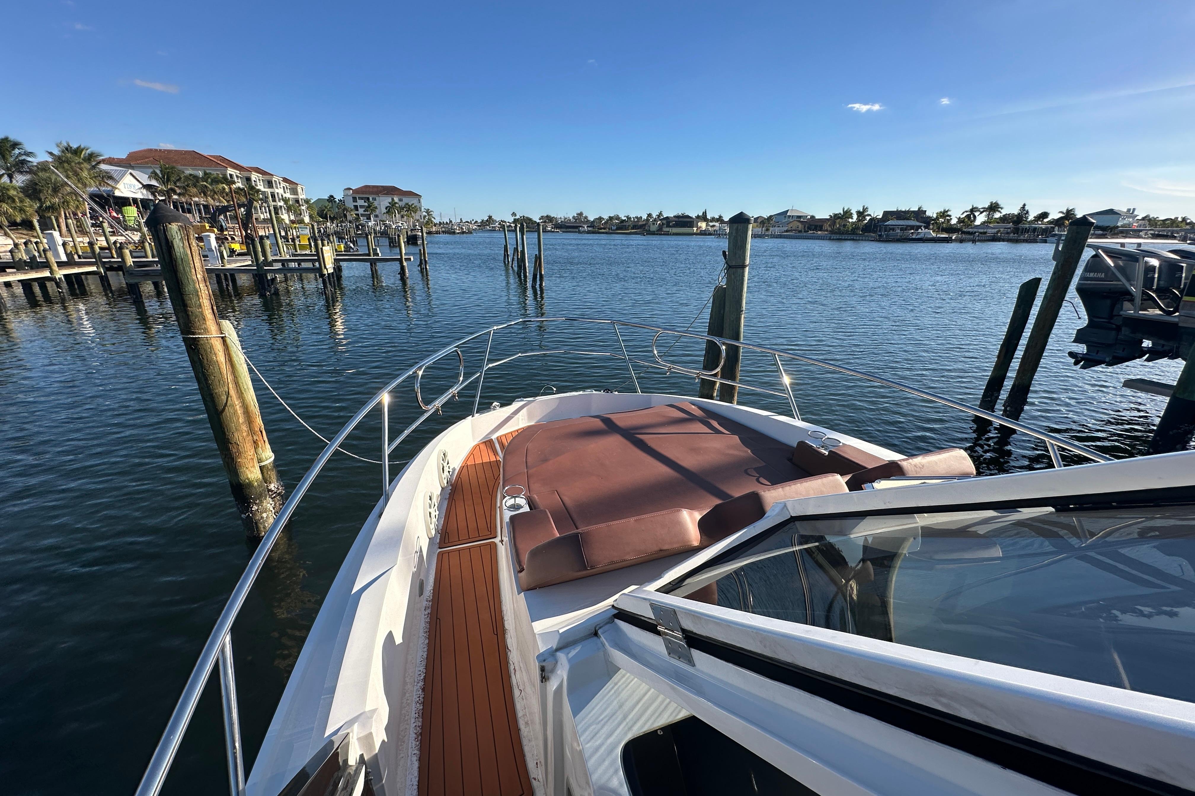 2025 NX Boats 370 docked in a scenic marina under clear blue skies.