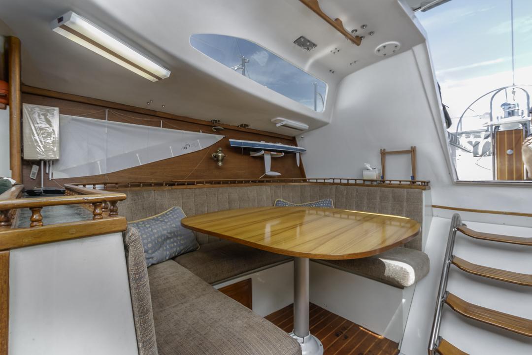 Interior of 1972 Columbia 43 Custom sailboat with wooden table and seating area.