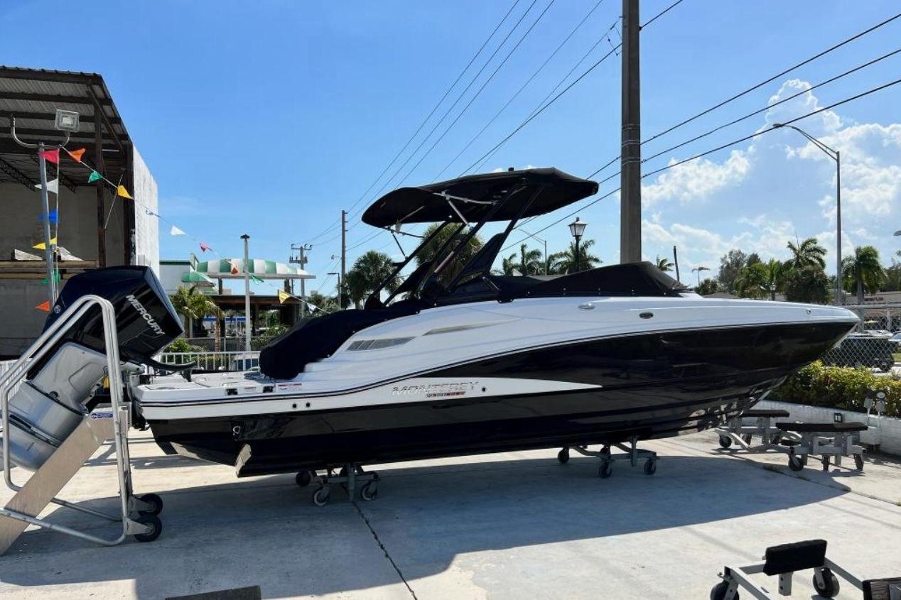2022 Monterey M-65 boat with Mercury engine, displayed outdoors under clear blue sky.