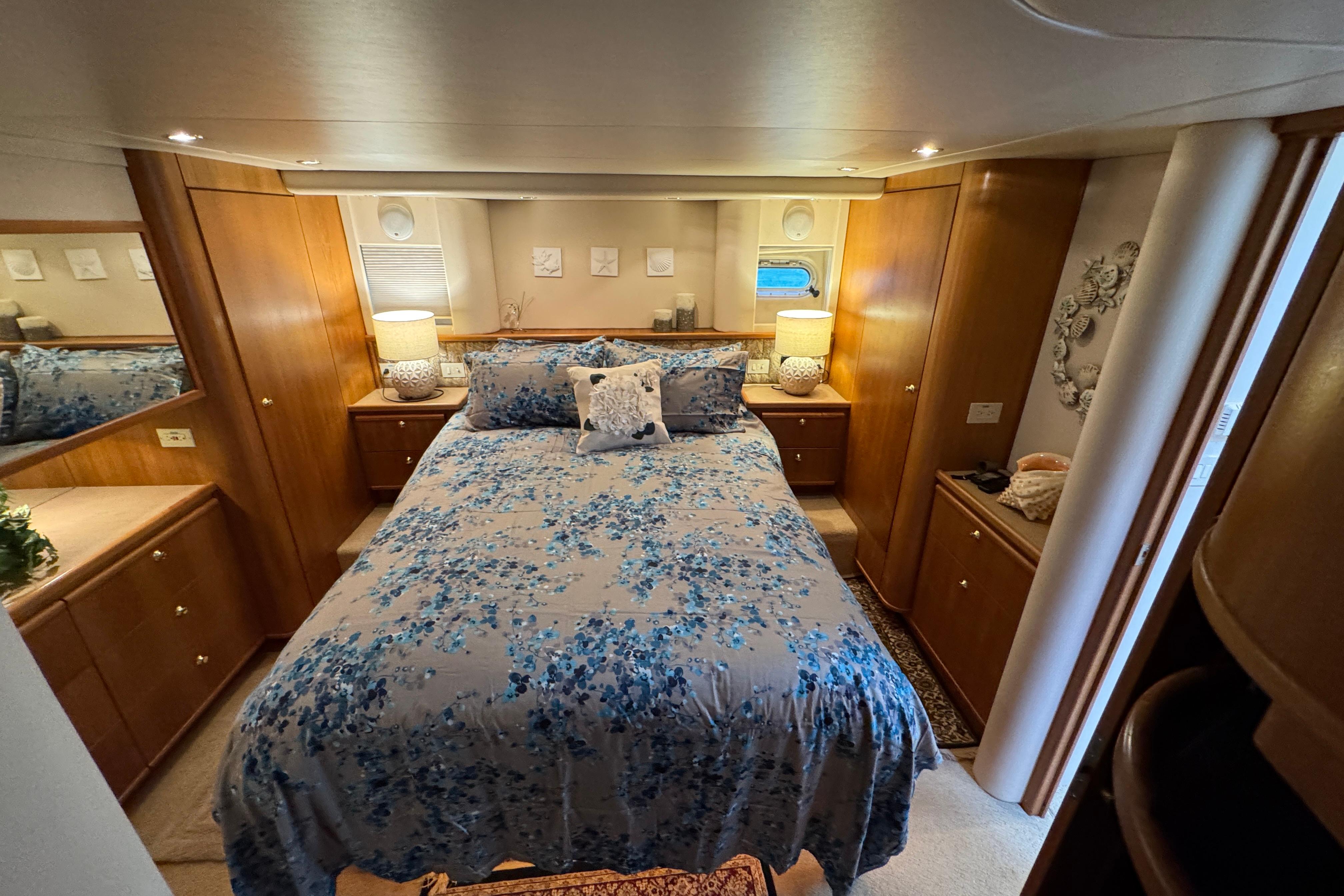 Luxurious bedroom interior of 1998 Bayliner 5788 Pilot House Motoryacht with elegant wood finishes.