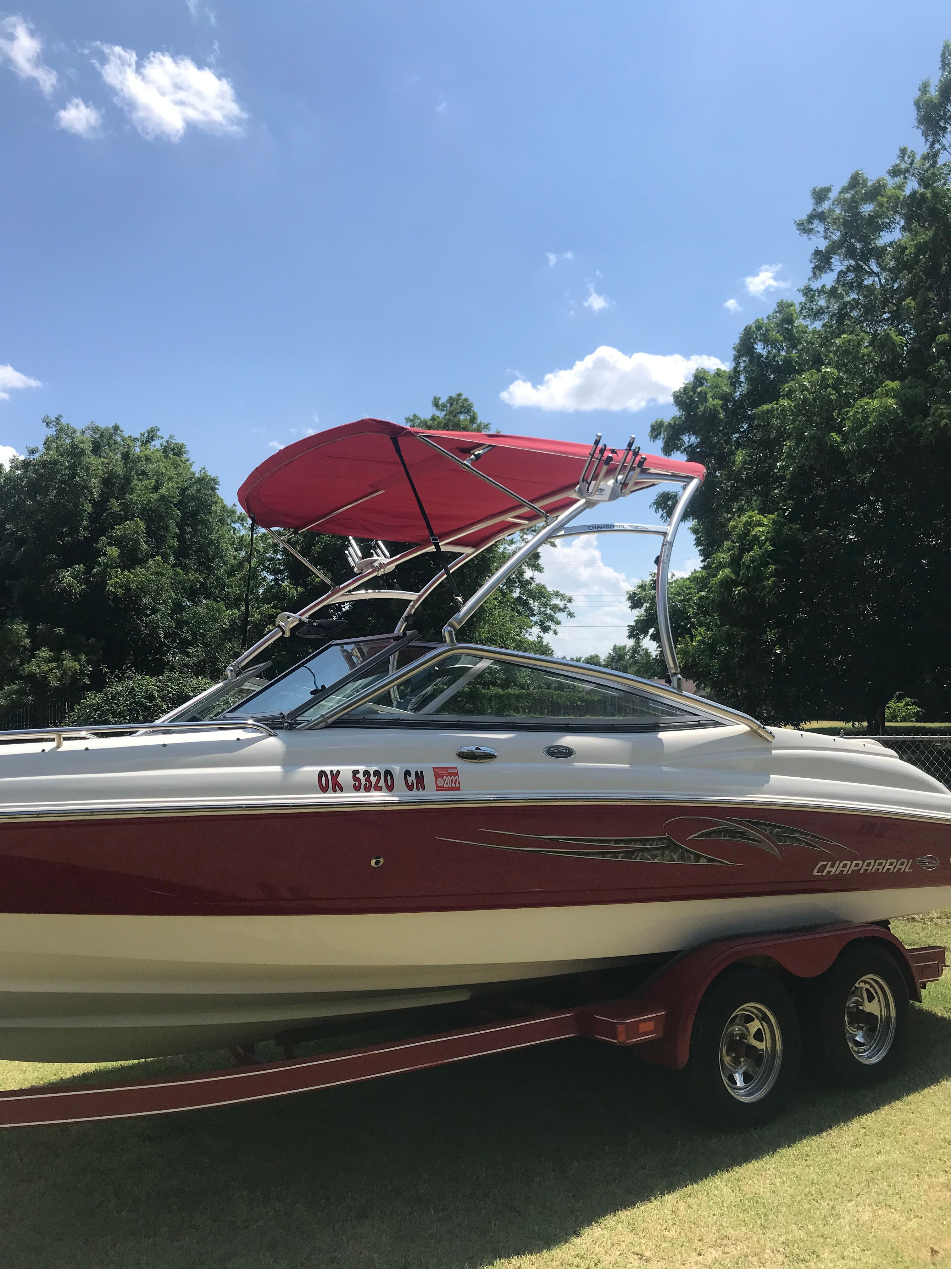 A red 2007 Chaparral 210 SSi boat on a trailer outdoors.