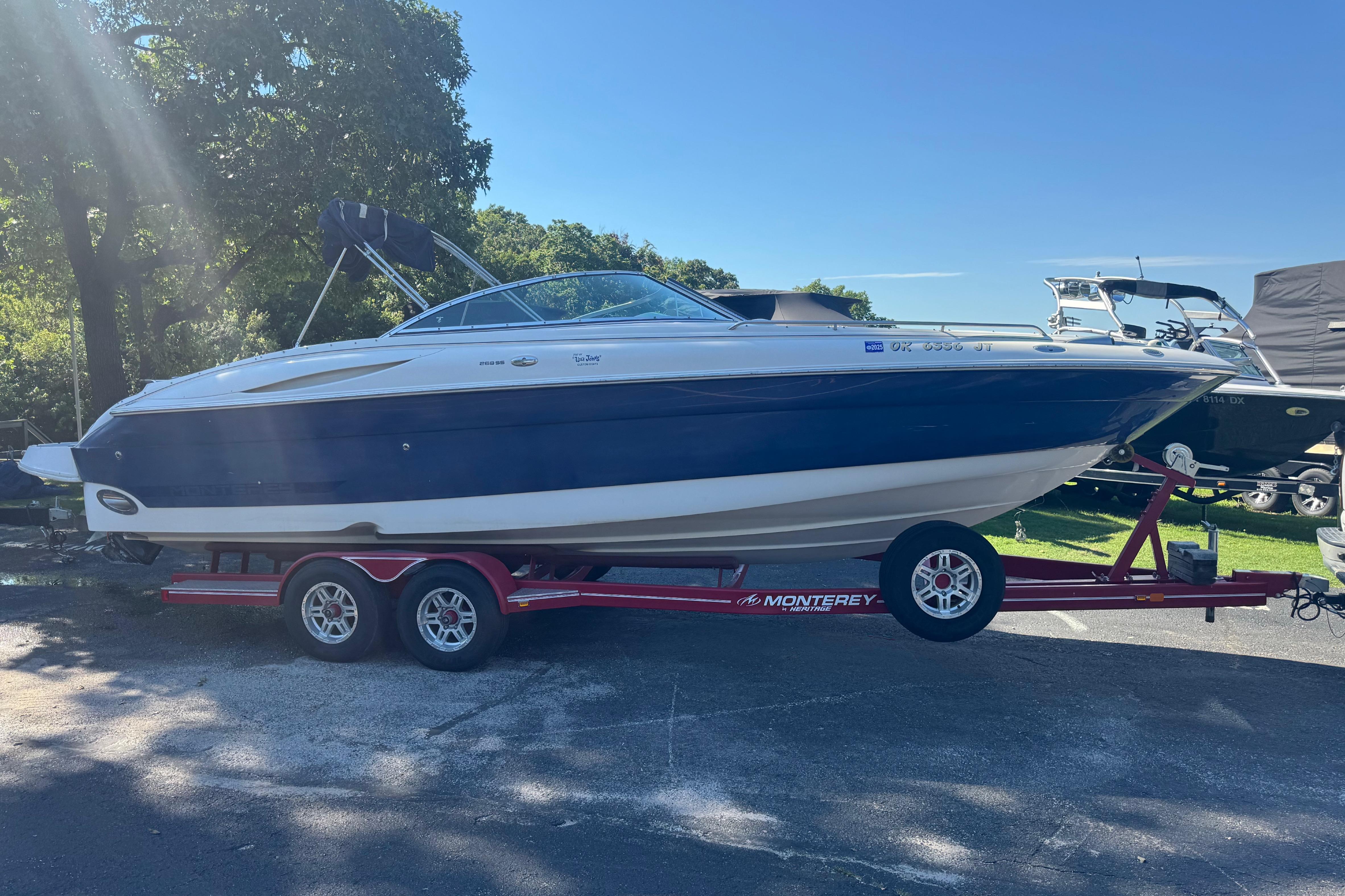 Monterey 268SS Super Sport boat on trailer, parked outdoors under clear sky.