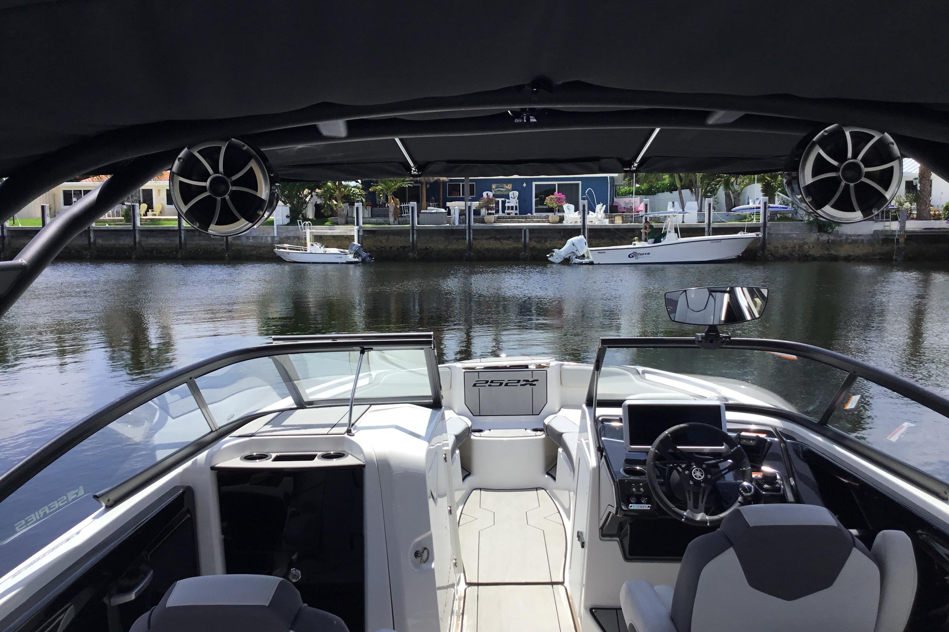 2023 Yamaha Boats 252XE interior view, featuring sleek design and advanced controls on a calm waterway.