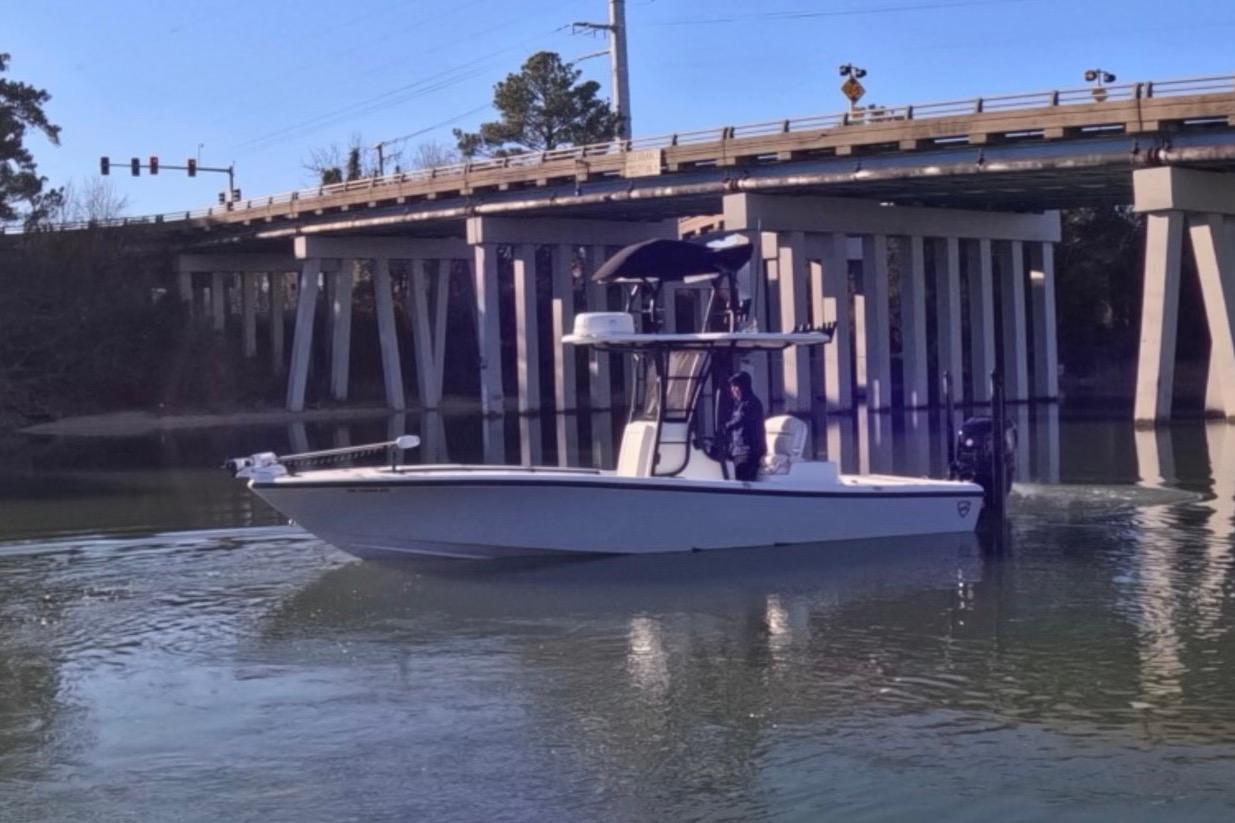 2017 Baker Boatworks 26 Open cruising under a bridge on a calm river.