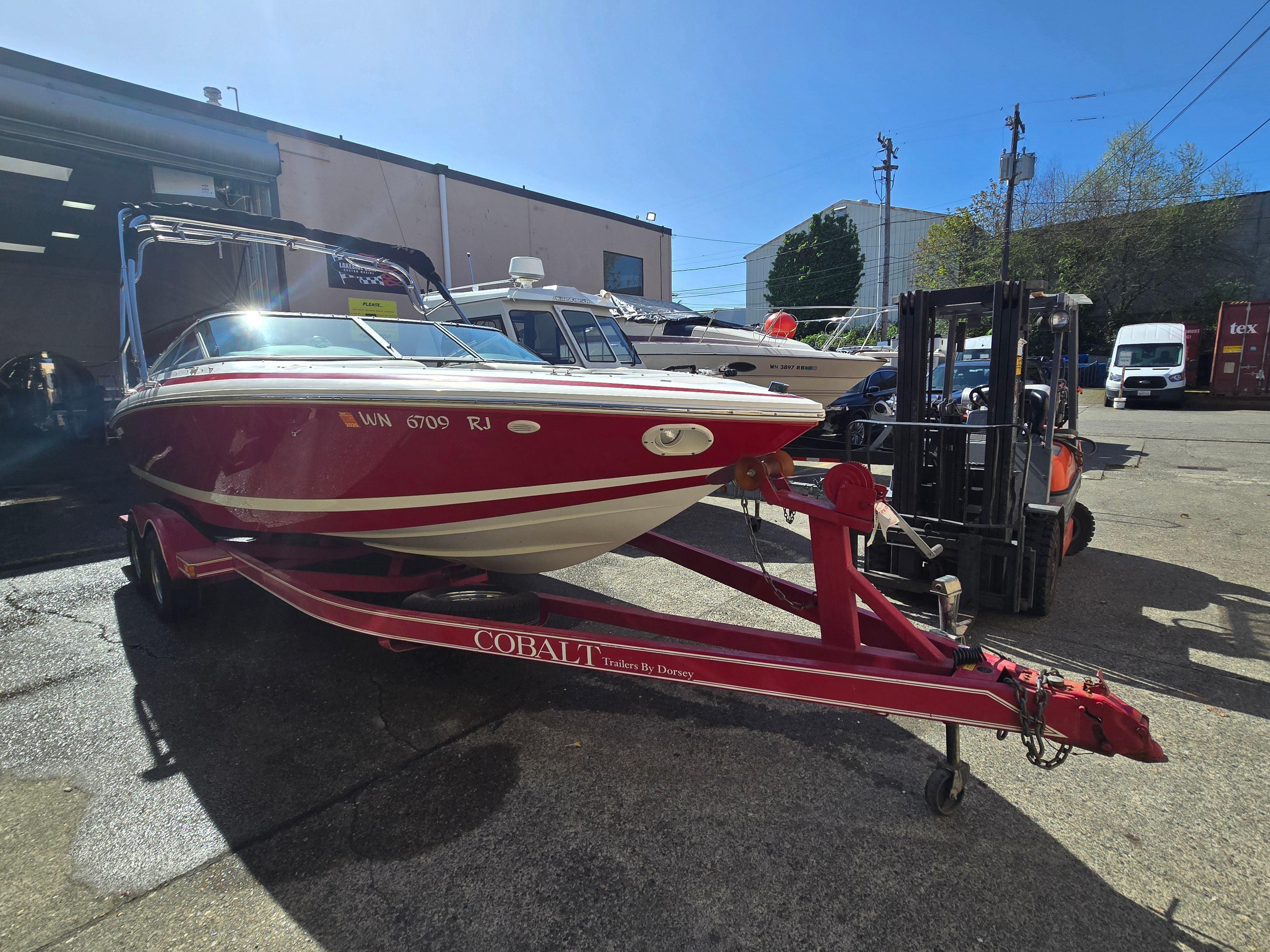 Red 2001 Cobalt 226 boat on trailer outdoors.