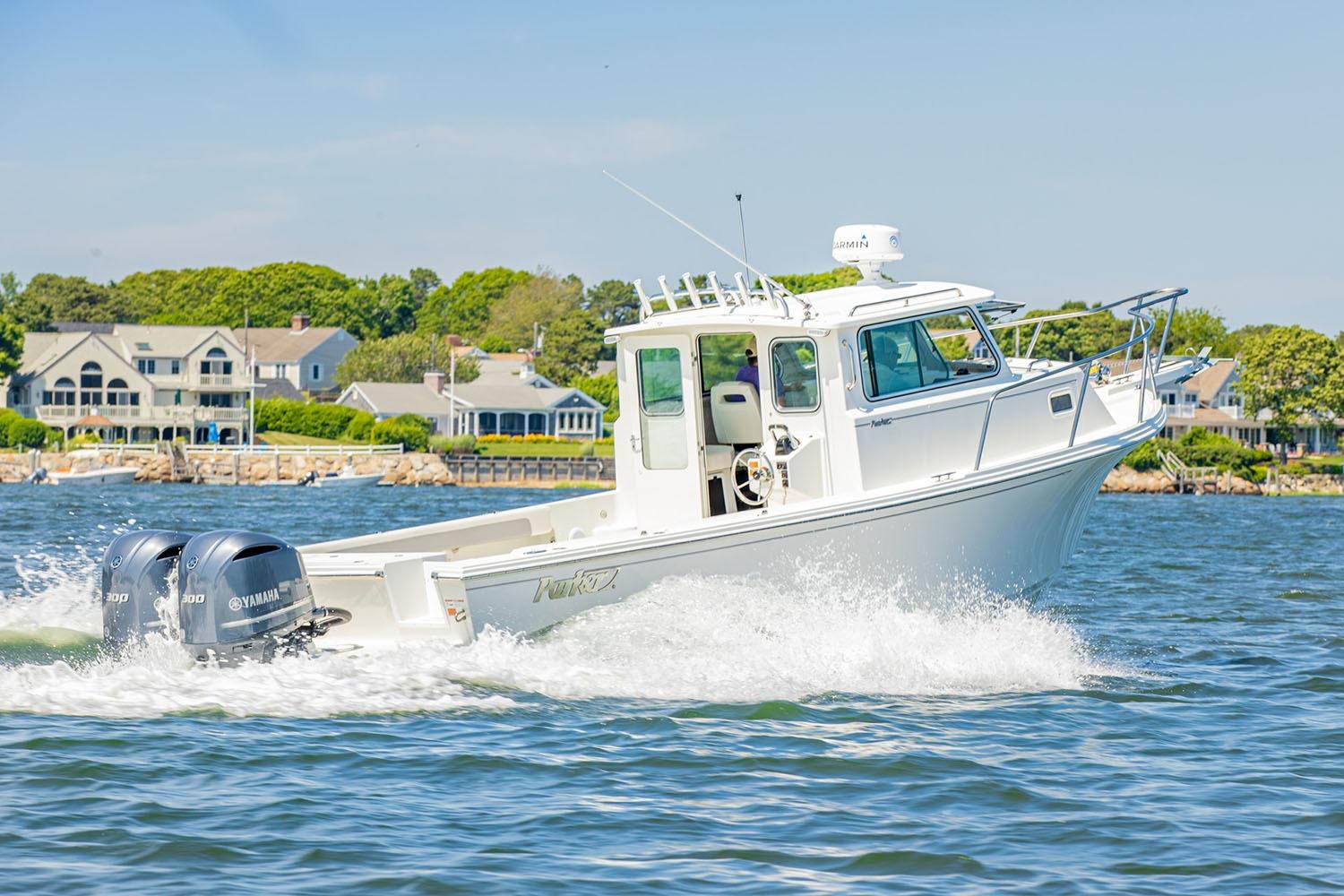 Manufacturer Provided Image: 2026 Parker 287 Explorer boat cruising on water near coastal homes.